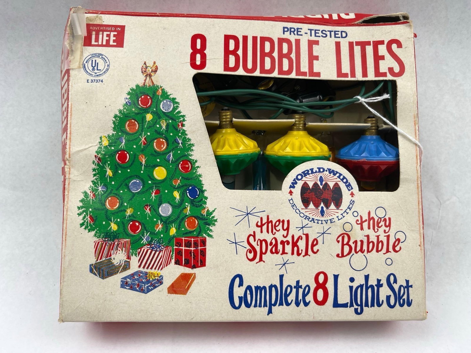 World Wide Enterprises Vtg Bubble Lites: A set of eight decorative bubble lights manufactured by World Wide Enterprises of Chicago, Illinois. The set includes eight individual bubble light bulbs, each featuring a saucer-shaped plastic base
