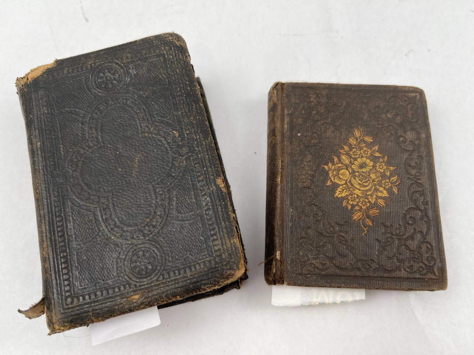 Carlton & Porter Religious Books, 1849: This lot features two mid-19th-century miniature religious volumes. It is bound in black embossed leather with a decorative stamped design. It is bound in brown embossed cloth or leather featuring a