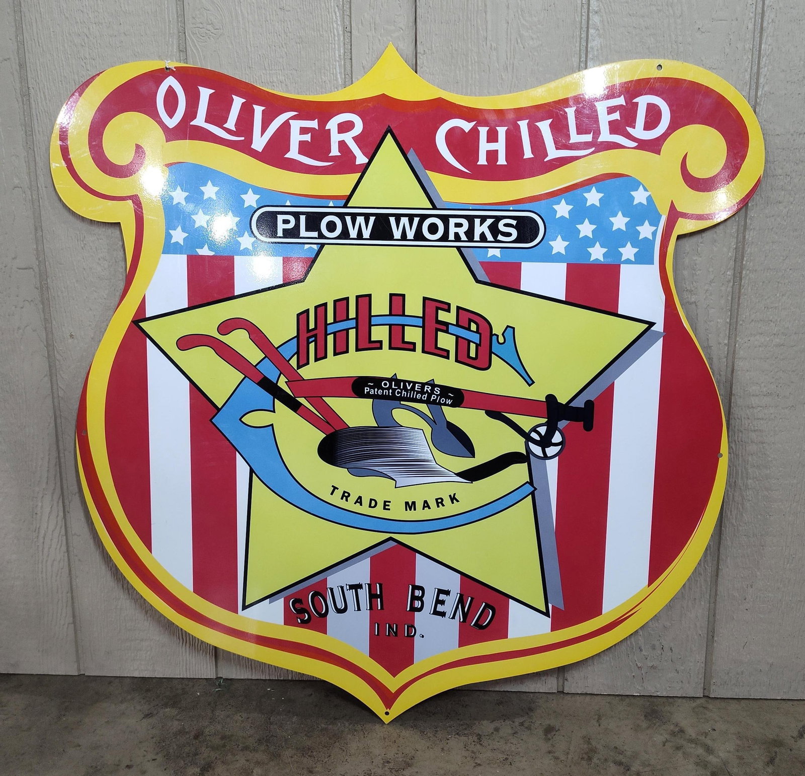 Oliver Chilled Plow Metal Shield Sign: A large die-cut metal advertising sign for the Oliver Chilled Plow Works of South Bend, Indiana. The sign is shaped as a formal crest or shield with a scrolled top and features a patriotic design moti