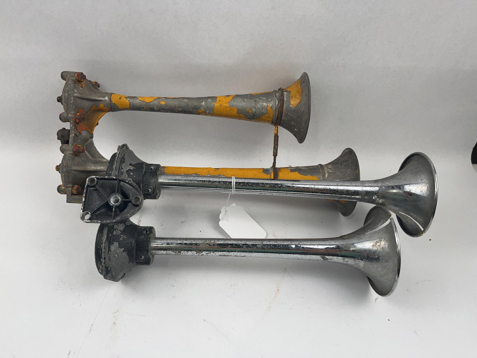 Bendix-Westinghouse & IH Dual Air Horns: This lot consists of two heavy-duty vintage dual air horn assemblies designed for commercial vehicle or industrial use. The trumpets are mounted to a single cast metal base. The rear chamber caps are 