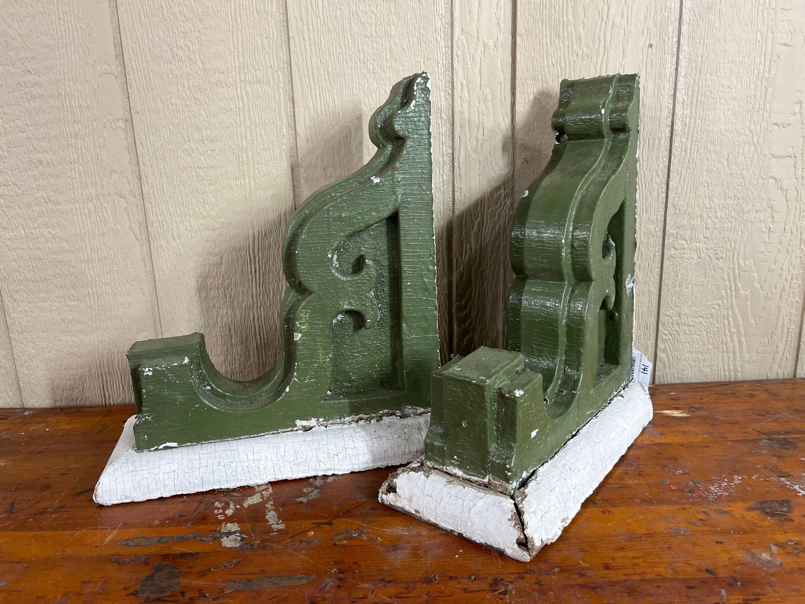 Pair Victorian Painted Wood Corbels: A pair of architectural salvage corbels or brackets featuring Victorian style scrollwork and tiered decorative profiling. These L-shaped supports are constructed from multiple laminated wooden boards,
