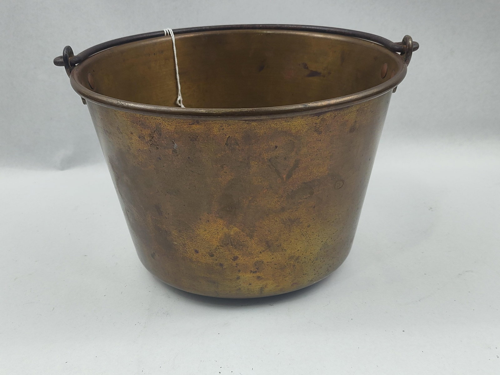 19th C. Spun Brass Bucket w/ Iron Bail: A 19th-century American utilitarian bucket featuring a heavy-gauge spun brass body with a reinforced rim rolled over an iron wire core. The vessel is fitted with a wrought iron bail handle. The
