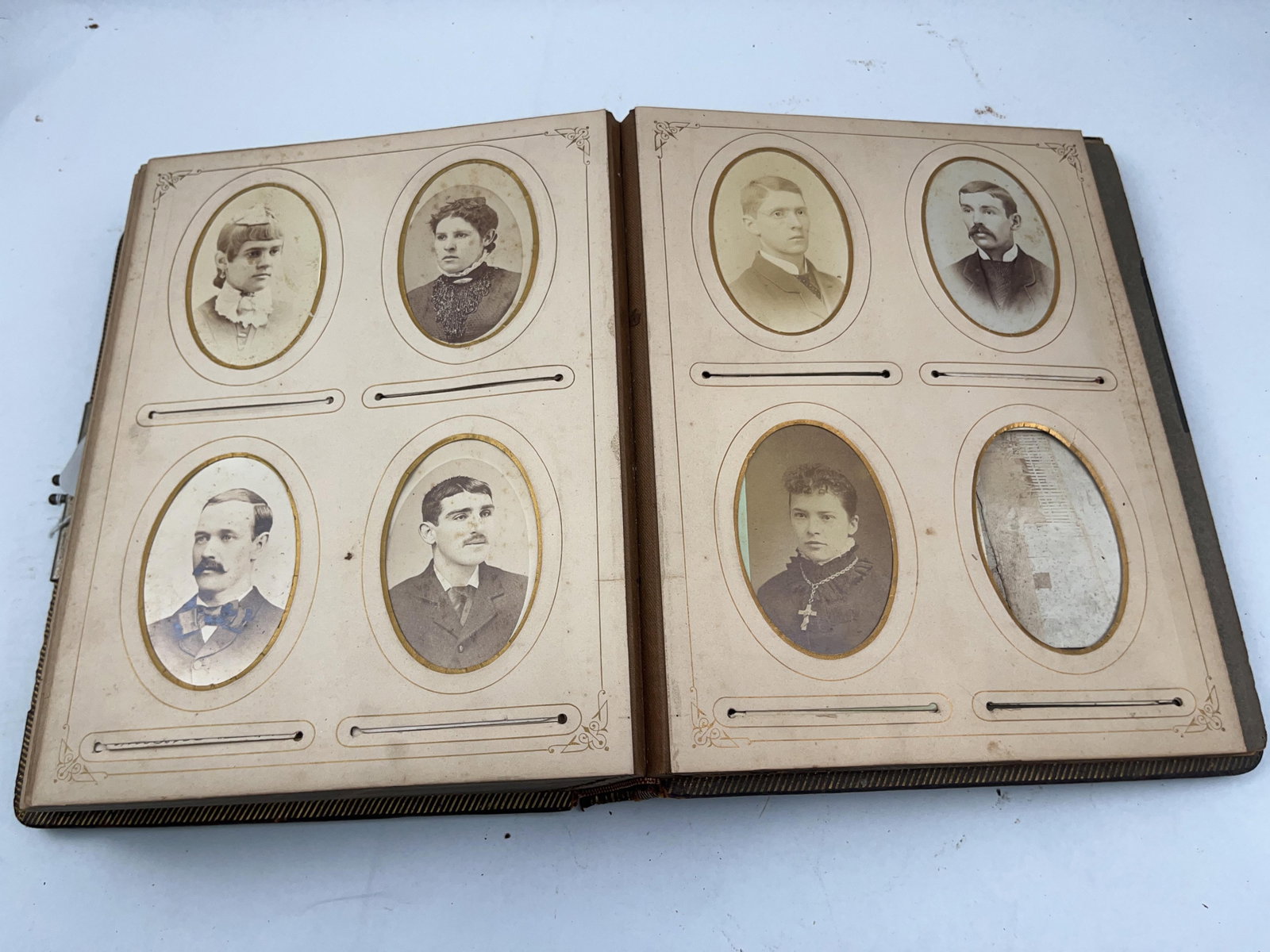 Victorian Gilt Leather Photograph Album: This Victorian-era photograph album is a large quarto volume bound in padded brown leather with a textured pebbled grain. The front cover is ornately decorated with the word ALBUM embossed in large,
