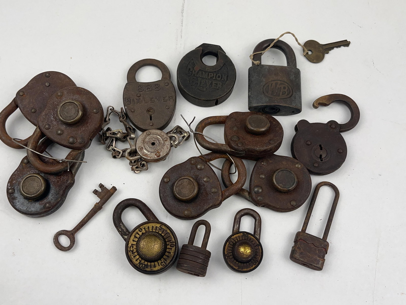 Junkunc, Champion & Sinclair Padlocks: A collection of antique and vintage industrial and utility padlocks constructed primarily from cast iron, steel, and brass. The assortment features a variety of locking mechanisms including lever,