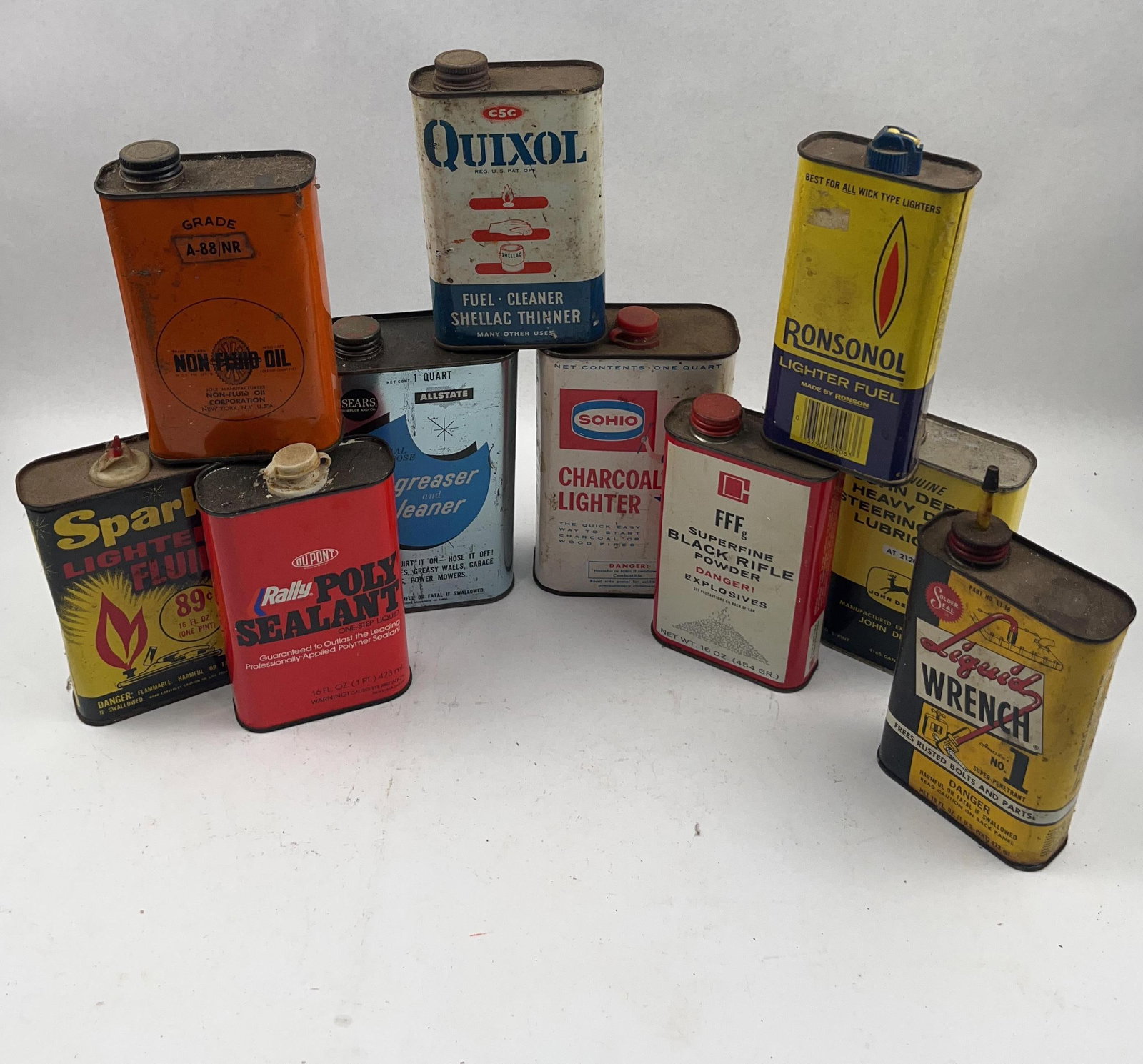 Set 10 Vtg Lithographed Auto Fluid Tins: This collection of ten vintage lithographed tin containers features a variety of automotive, industrial, and household fluids primarily from the mid-20th century. The group includes a one-quart Sears