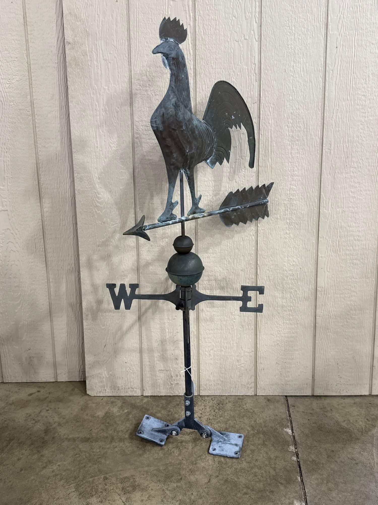 Copper Rooster Weathervane w/ Mount: A swell-bodied copper figure of a crowing rooster featuring a serrated comb and stylized tail feathers. The rooster stands atop a directional arrow. The assembly includes two decorative copper globes 