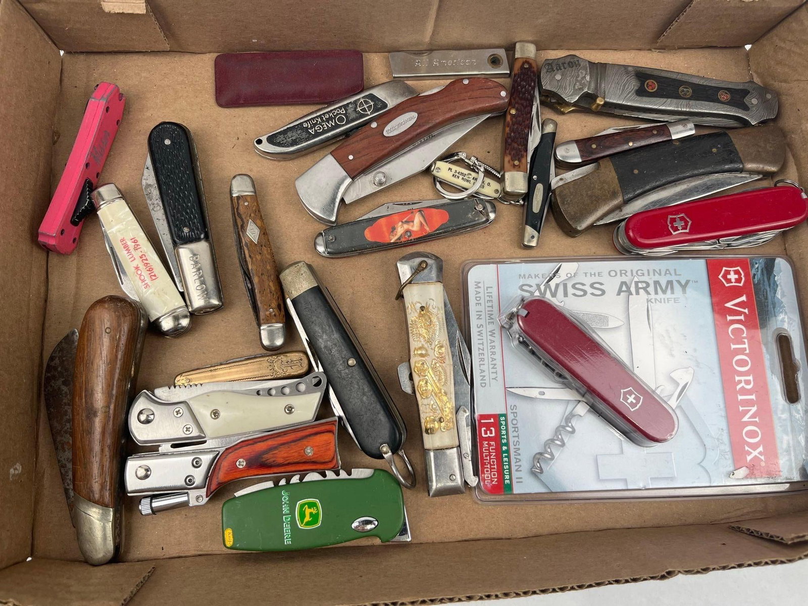 Victorinox & Winchester Knives & Tools: A large assortment of folding pocket knives, multi-tools, and utility cutters in various patterns, sizes, and handle materials. The group includes a Swiss-made Victorinox multi-tool in original