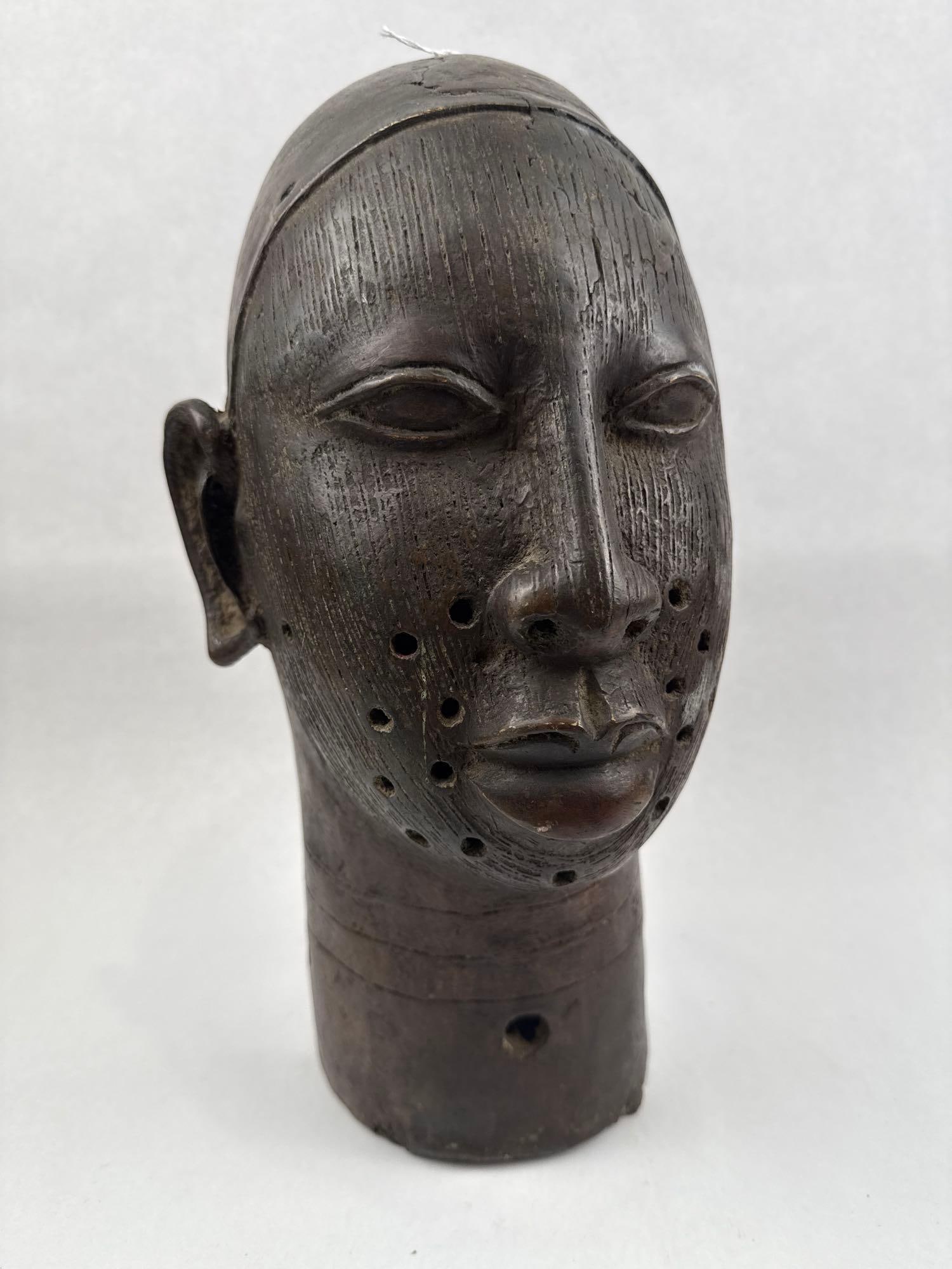 Nigerian Cast Metal Head of an Oba: A hollow-cast metal commemorative head, rendered in a style consistent with the Benin and Ife traditions of Nigeria, featuring a dark brown patina over a bronze or brass alloy. The face is detailed
