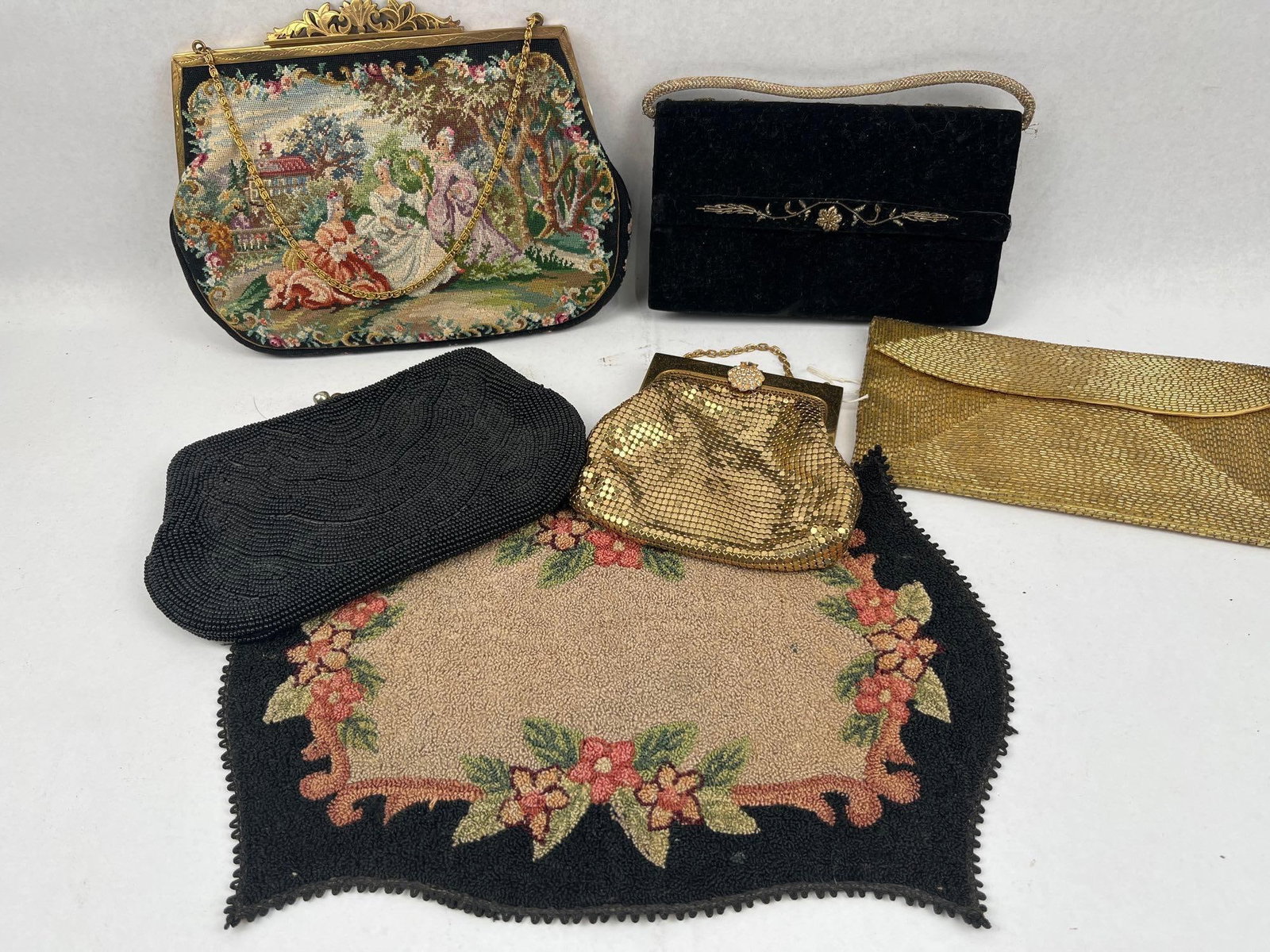 Whiting & Davis & Walborg Evening Bags: An assortment of mid-20th-century vintage evening bags and a decorative textile mat. Included is an Austrian petit point handbag featuring a classical pastoral scene with figures in an outdoor garden 