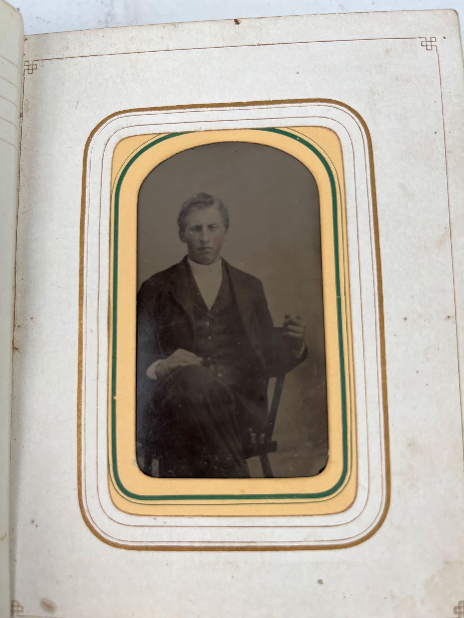 Victorian Leather Photo Album: Tintypes: A Victorian-era photograph album featuring a brown leather binding with deeply embossed scroll and foliate motifs on both covers. The album is secured with two ornate brass clasps and contains cardsto