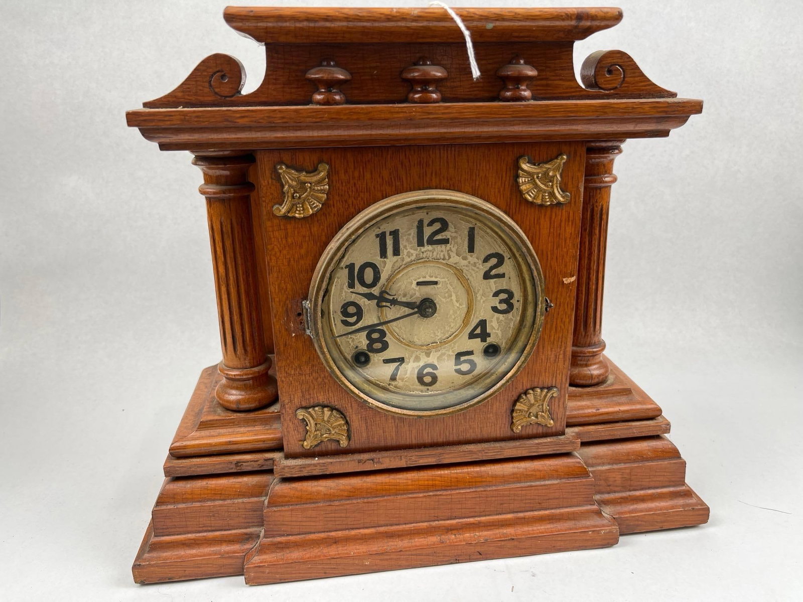 19th C. American Arch. Oak Mantel Clock: An American oak mantel clock of architectural form, featuring a case with a stepped pediment top adorned with three turned bosses and scrolled ears. The central housing is flanked by fluted pilasters 
