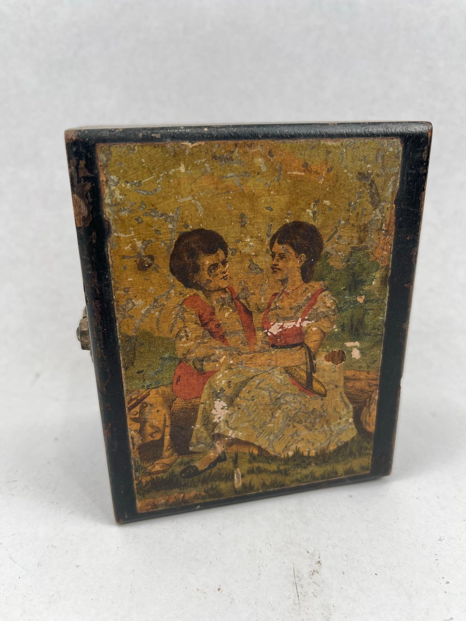 S.W.H. Ward's Sons Painted Collar Box: A late 19th-century American wooden collar box featuring a black-painted exterior and a natural wood interior. The lid is inset with a chromolithograph depicting a young couple in rustic dress seated