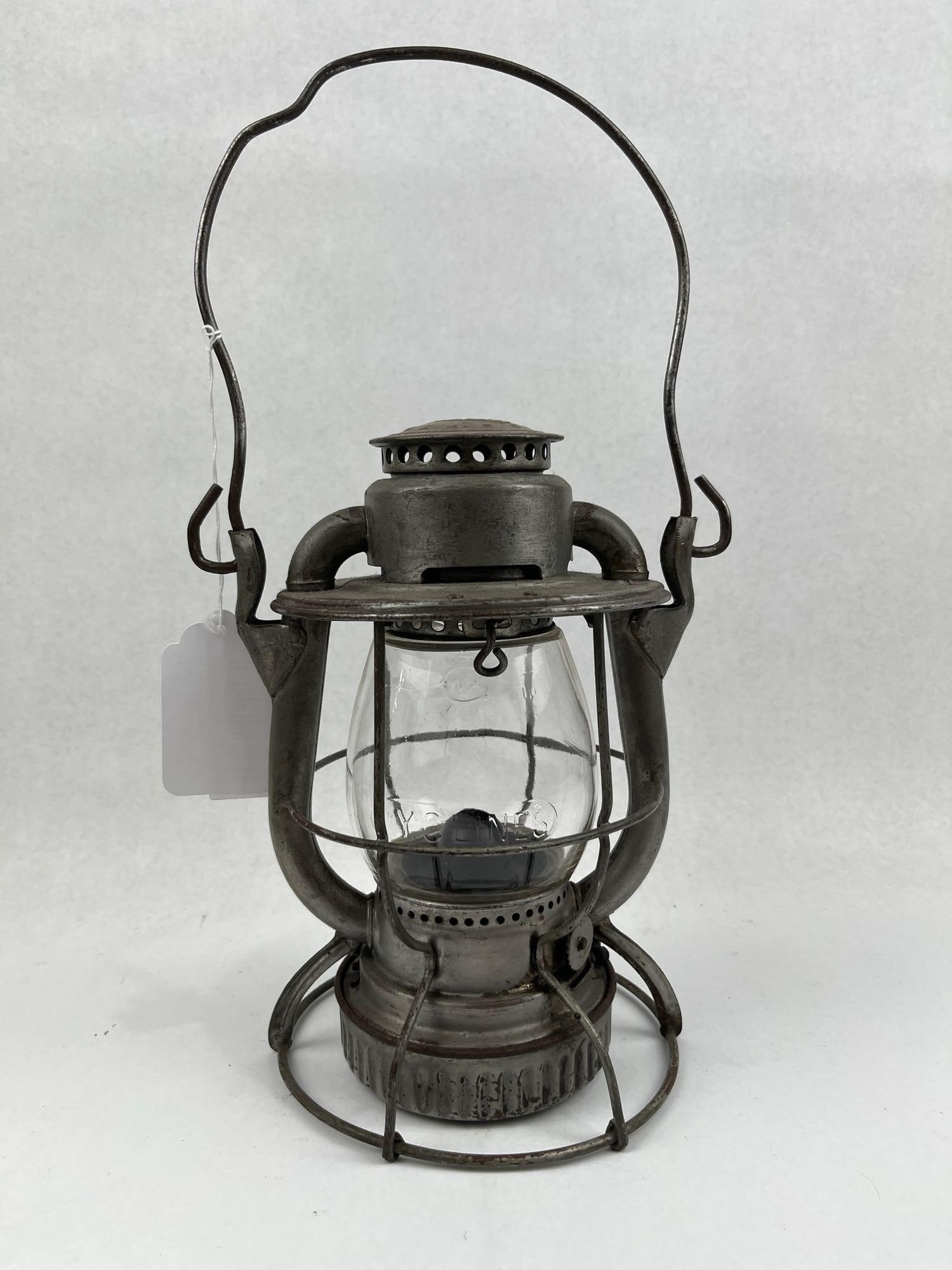 Dietz Vesta Railroad Lantern w/ Globe: This Dietz Vesta railroad lantern features a galvanized steel frame with a protective wire cage and a clear glass globe. The top cap is impressed with an oval logo containing the text DIETZ VESTA,