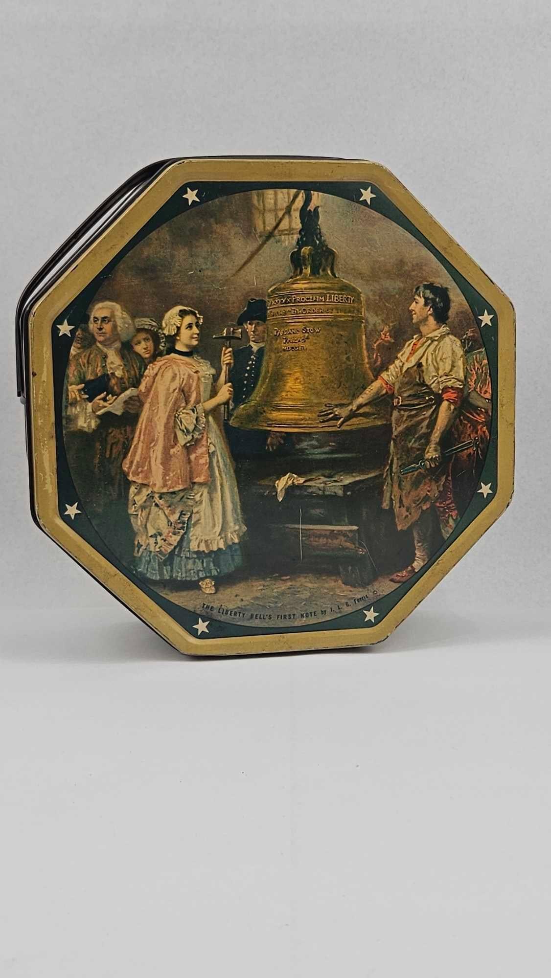 Sunshine Biscuits American History Tin: A US-made octagonal lithographed tin biscuit container manufactured by Sunshine Biscuits, Inc. The container features a swing-style dark metal handle and a removable lid. The exterior is decorated