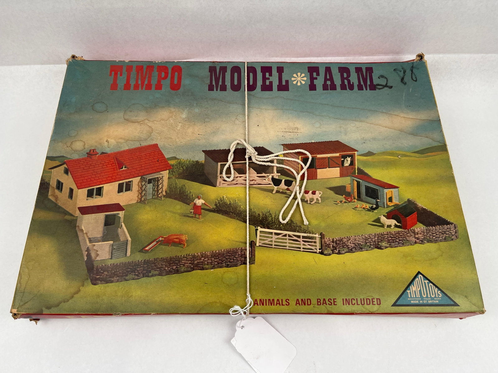 Timpo Farm Set w/ Massey-Harris Tractor: A British-made Timpo Toys Model Farm playset. The set is housed in its original illustrated cardboard box. The collection includes an assortment of plastic building components such as white wall