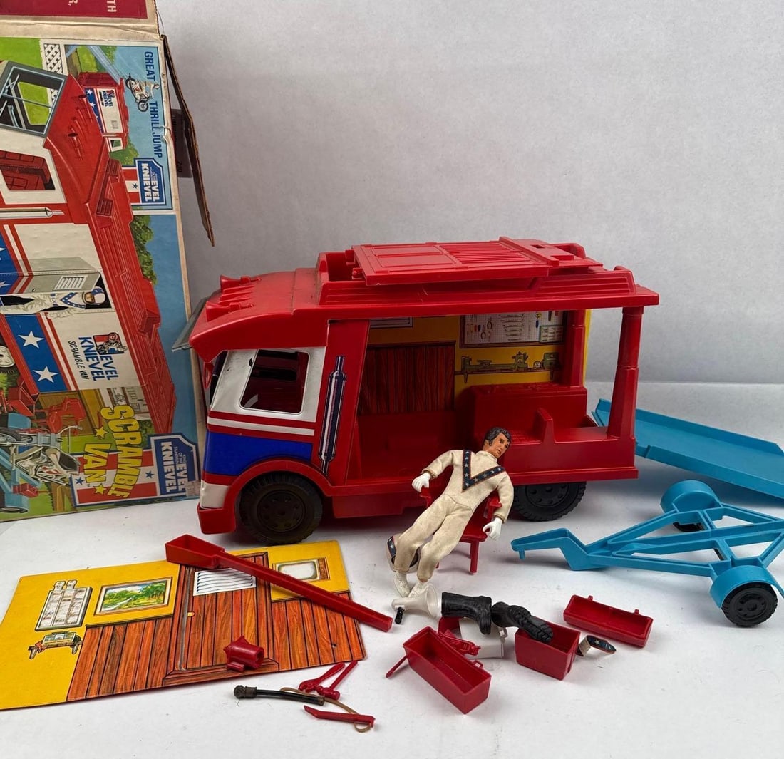 1973 Ideal Evel Knievel Scramble Van: This vintage 1973 Ideal Toy Corp. Evel Knievel Scramble Van playset includes a red, white, and blue plastic vehicle with a side panel that folds out to reveal a service station interior with a