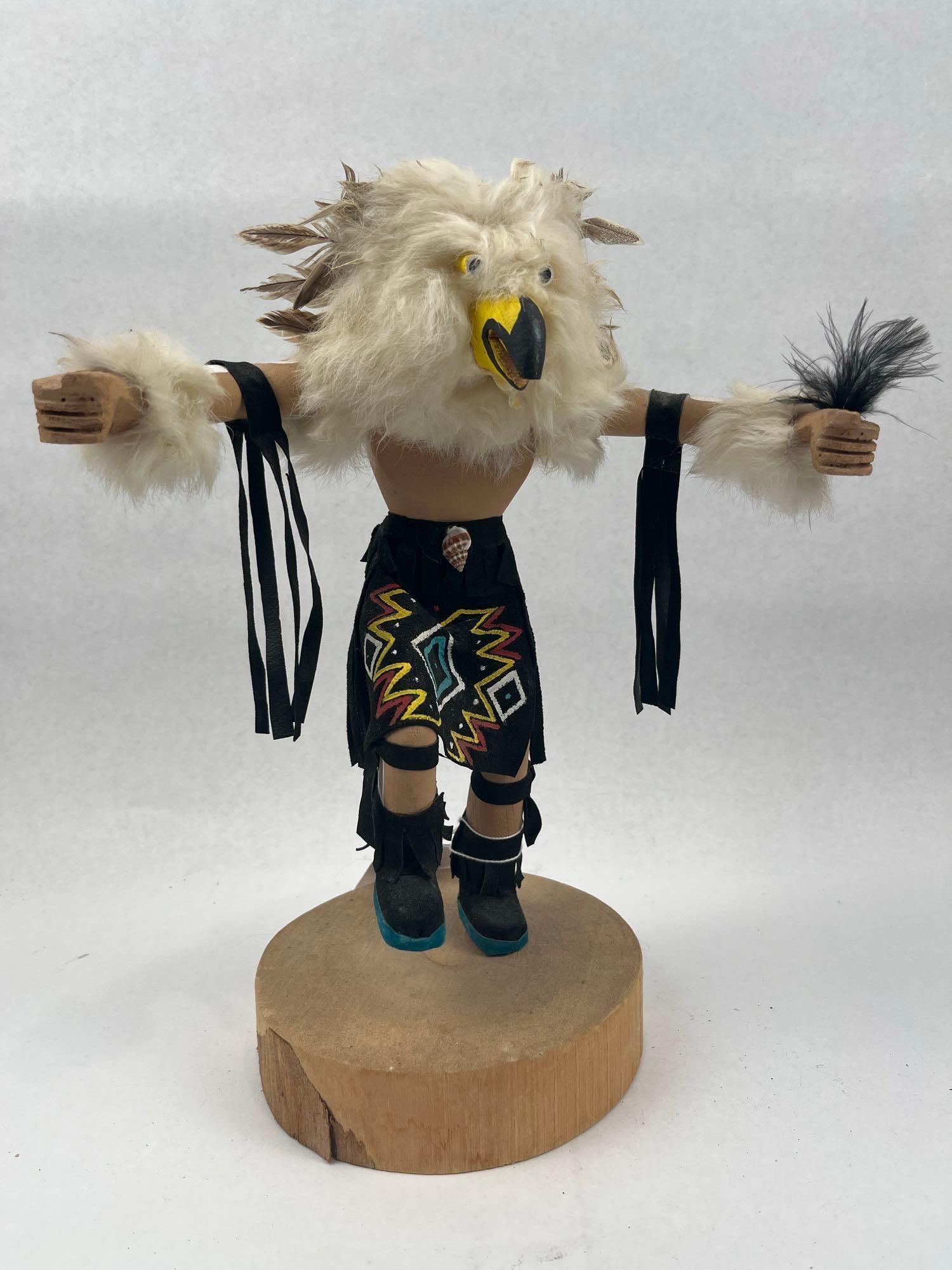 C. Kenneth (Navajo) Owl Kachina Doll: A handcrafted Navajo kachina doll representing an owl, constructed from carved wood with various mixed media embellishments. The figure features a head covered in white fur with brown-tipped feathers