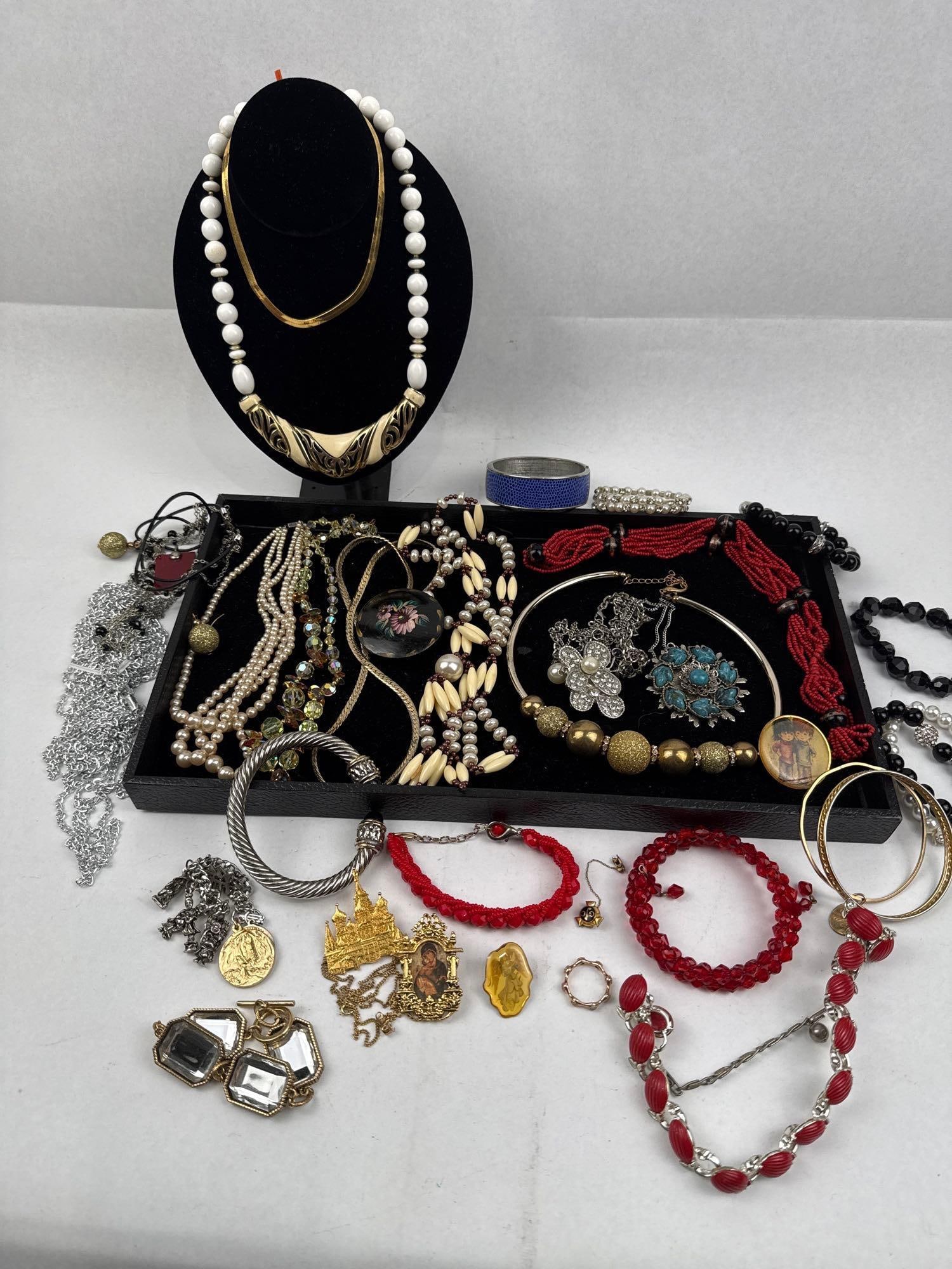 Costume Jewelry Collection: An assortment of vintage and contemporary costume jewelry featuring a wide range of styles, materials, and periods. The collection includes various necklaces, bracelets, bangles, and charms. Notable p