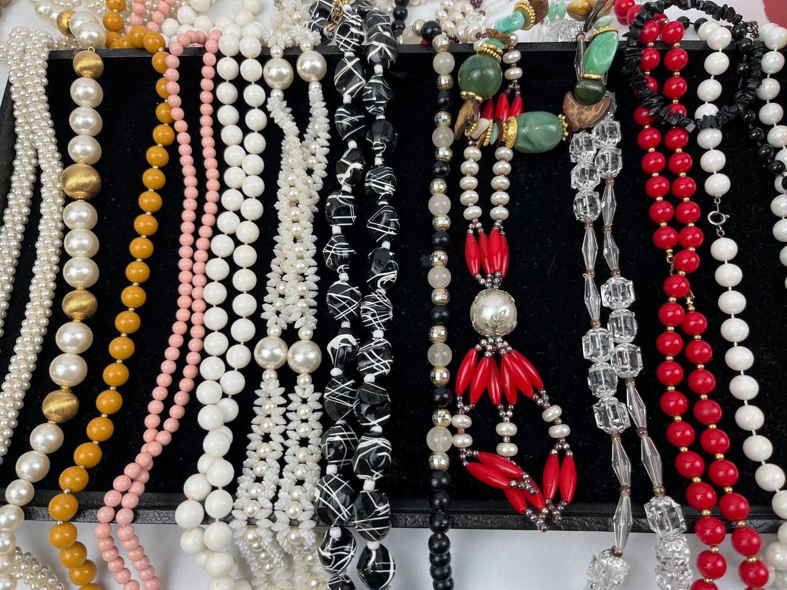 Collection Beaded Fashion Necklaces: This collection comprises an assortment of fashion necklaces featuring a variety of bead styles, materials, and colors. The selection includes multiple strands of faux pearls in varying sizes and