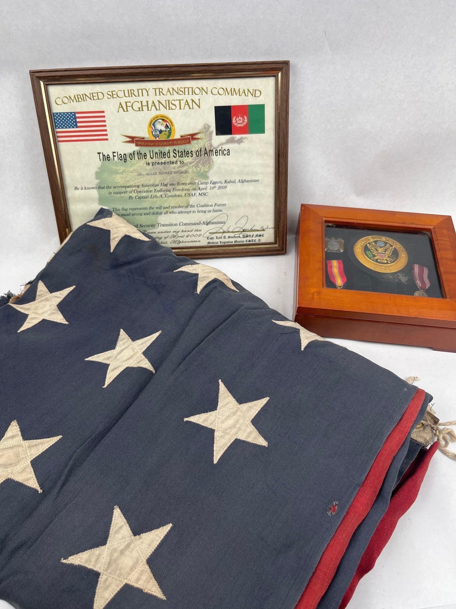 Defiance 48-Star Flag & Military Trio: A commemorative military presentation grouping consisting of a vintage American 48-star flag, a framed presentation certificate, and a wooden shadow box containing insignia and medals. The United Stat