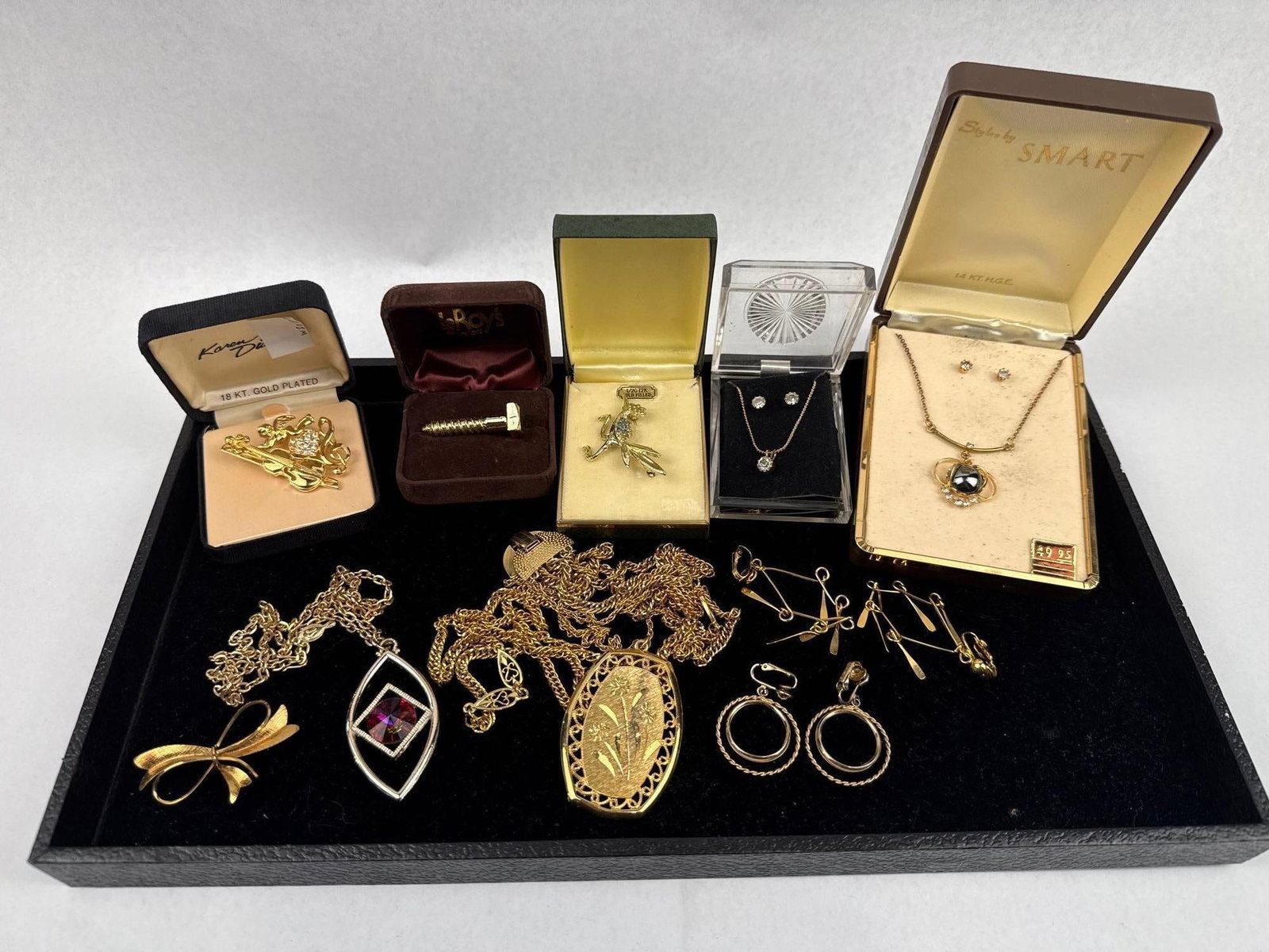 Gold-Filled & Plated Costume Jewelry: An assortment of vintage costume jewelry, primarily gold-toned, featuring several items in original presentation boxes. One piece is a brooch depicting a violin and a cherub set with clear