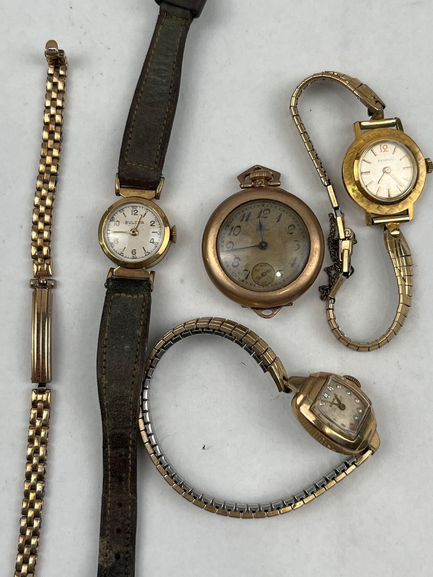 Elgin Bulova Benrus Watches & Kreisler: An assortment of four vintage timepieces and one gold-tone bracelet. The collection includes: An Elgin open-face pocket watch featuring a manual-wind movement engraved ELGIN U.S.A. with serial number