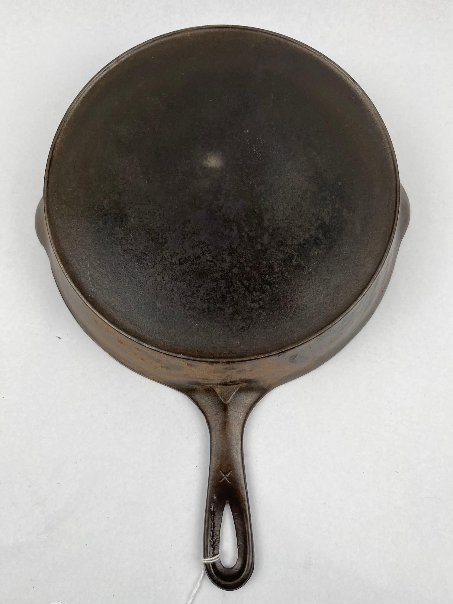 Cast Iron Skillet, Heat Ring & Mark: A vintage American cast iron skillet of circular form with two integrated side-pouring spouts. The integral handle is designed with a teardrop-shaped hanging aperture and a V-shaped reinforcement at t