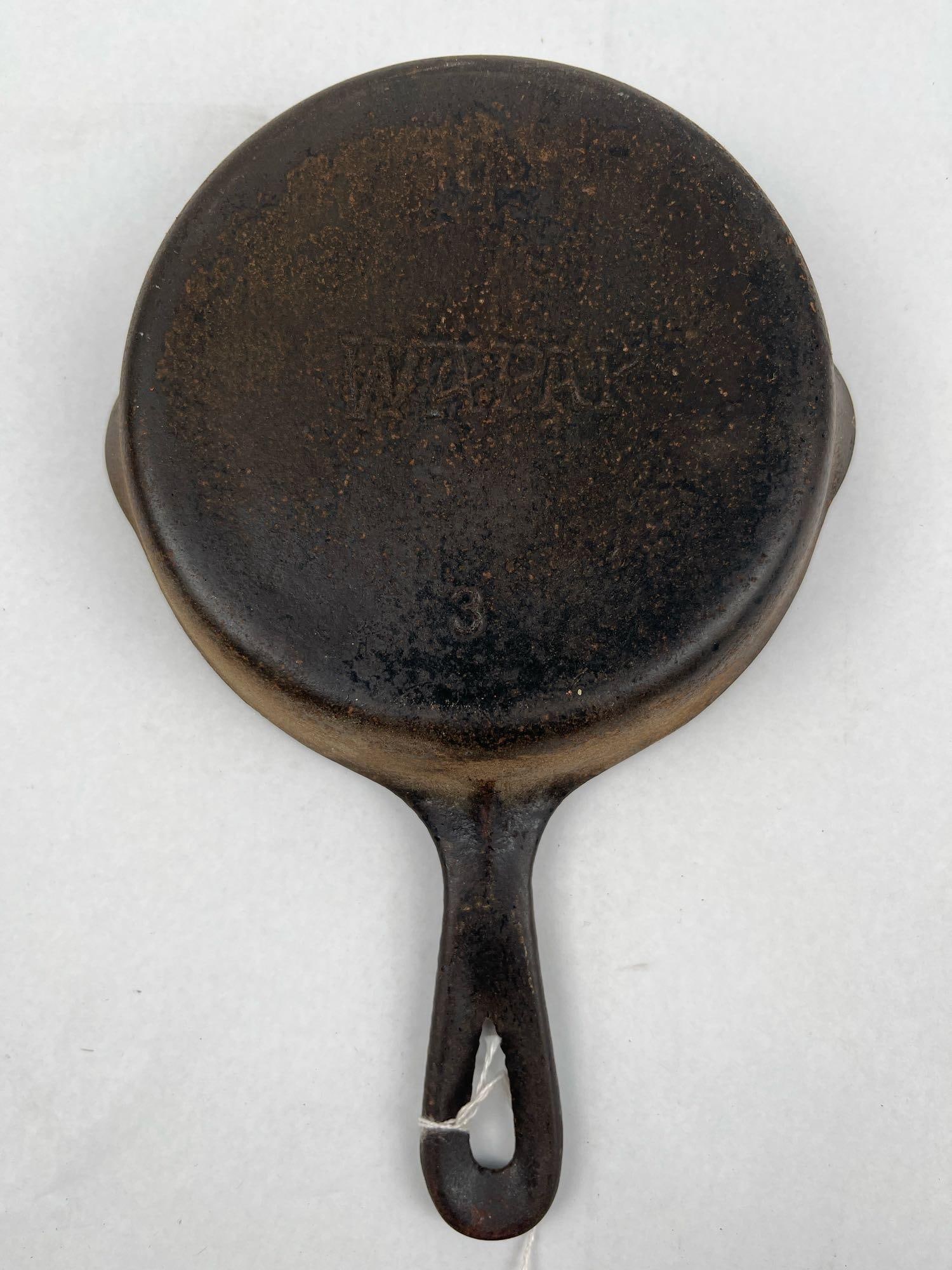 Wapak No. 3 Cast Iron Skillet: An American-made size No. 3 cast iron skillet manufactured by the Wapak Hollow Ware Company of Wapakoneta, Ohio. The pan is designed with a flat bottom, two pour spouts, and a handle featuring a teard