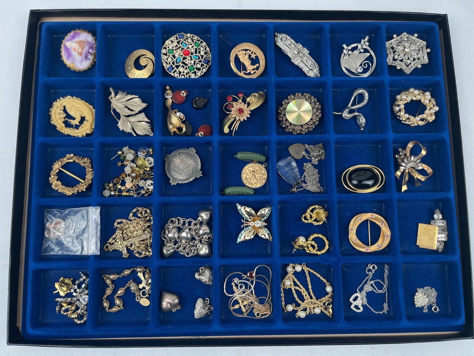 Str. & Novelty Jewellery: An assortment of vintage costume jewellery and sterling silver items, presented in a blue velvet-lined compartmentalised display tray. The collection features several brooches in various styles,