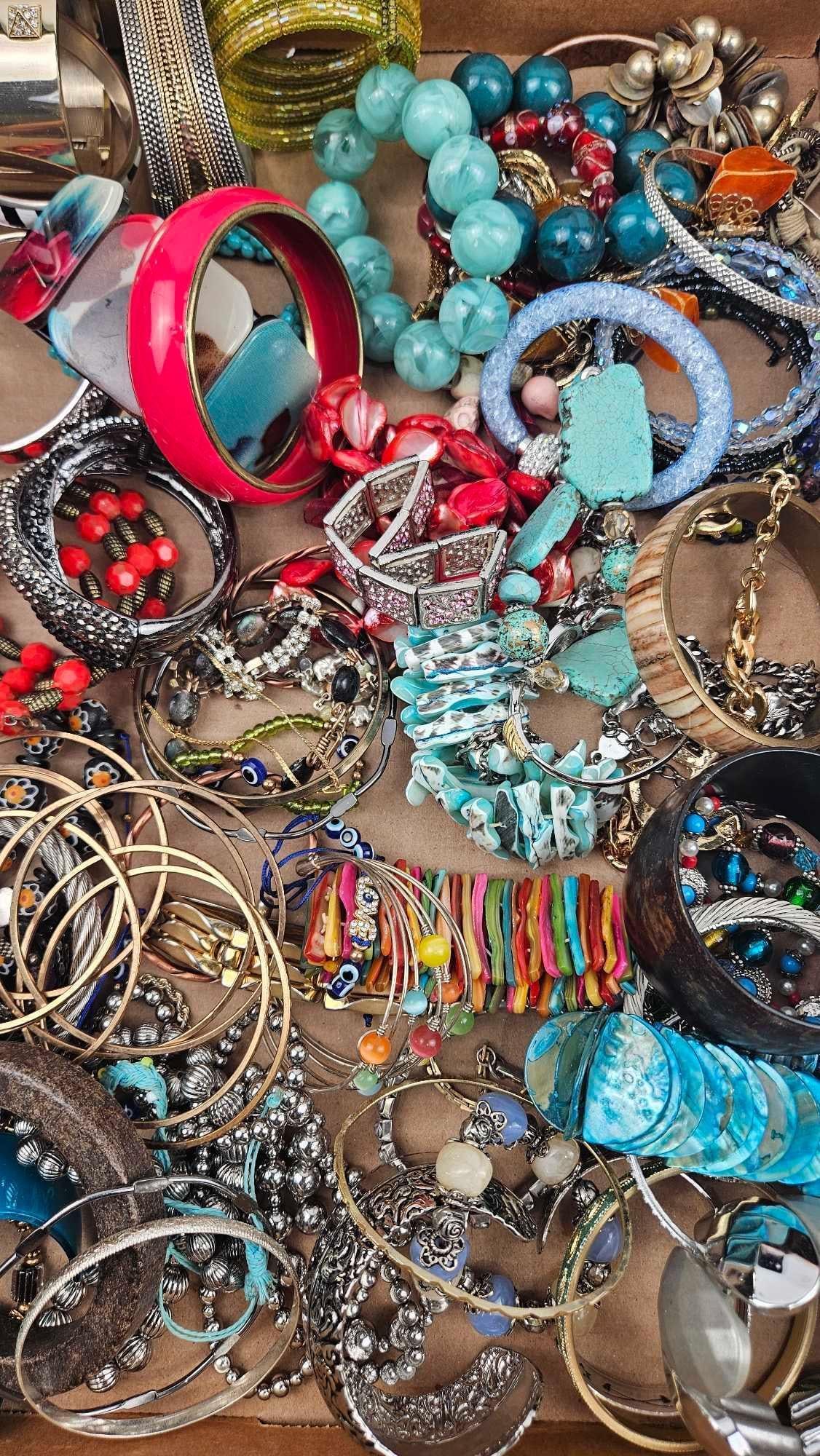 Costume Jewelry Bracelets & Bangles: An assortment of costume jewelry consisting of various bracelets and bangles in a wide range of materials and styles. The collection includes wide plastic and enamel bangles in solid colors like