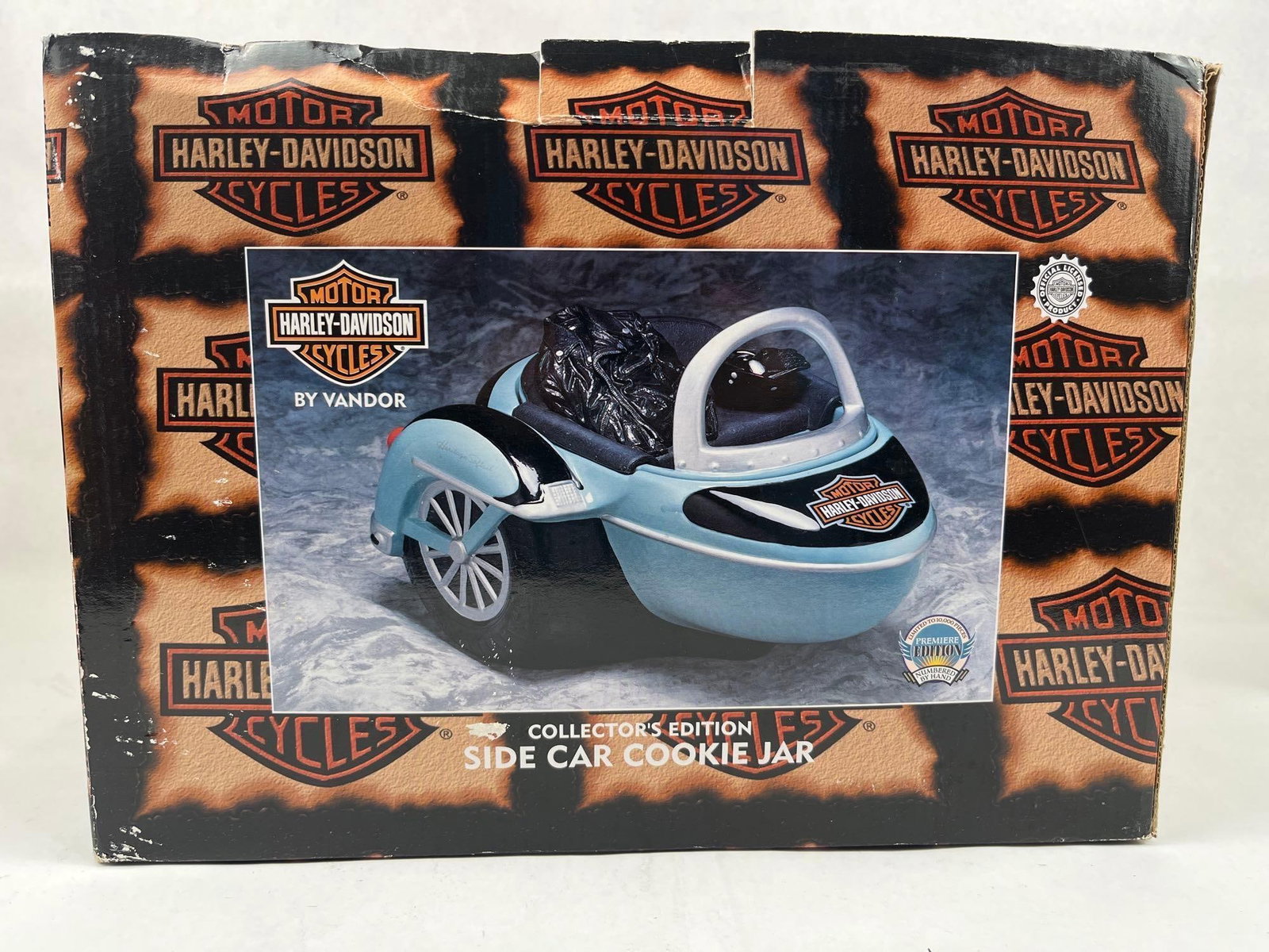 Vandor Harley-Davidson Sidecar Jar: This ceramic cookie jar is designed in the form of a motorcycle sidecar and is finished in a light blue and black color scheme. The piece features the printed "MOTOR HARLEY-DAVIDSON CYCLES" Bar and