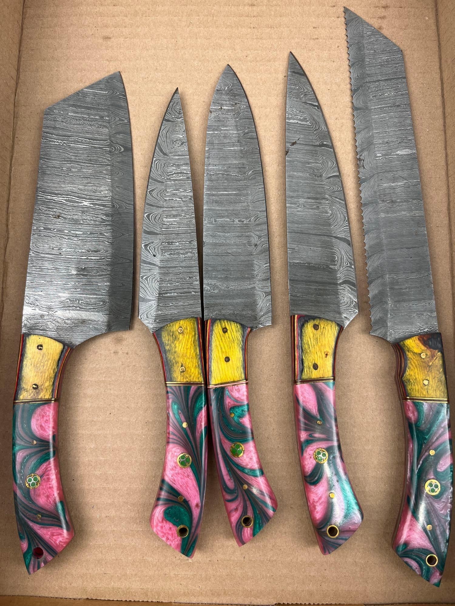 Set Damascus Steel Kitchen Knives: A set of culinary knives featuring pattern-welded Damascus steel blades and vibrant multi-material handles. The group includes a cleaver, several utility or chef style knives, and a serrated bread
