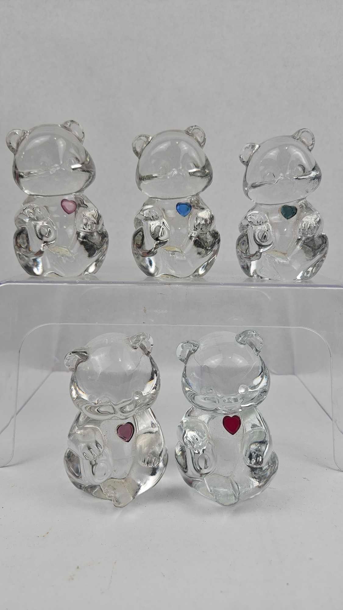 Fenton Art Glass Birthstone Bear Set: A collection of seated teddy bear figurines fashioned from molded clear glass. The figures feature anatomical details including rounded ears, snouts, and paws. Each bear is inset with a single