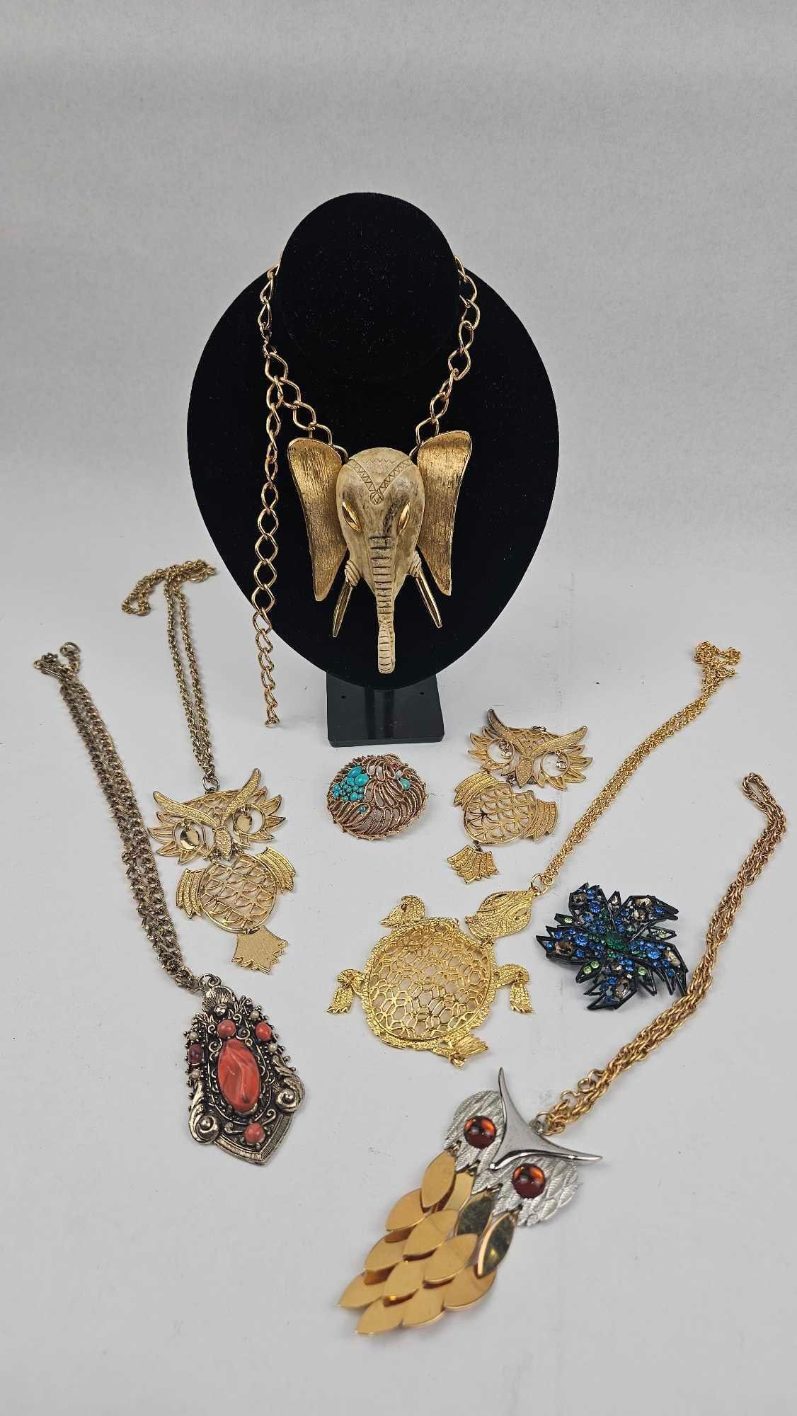 Animal Motif Costume Jewelry Set: ** An assortment of vintage costume jewelry, including several necklaces and brooches featuring animal and figurative themes. The pieces are constructed from gold-tone and silver-tone base metals and