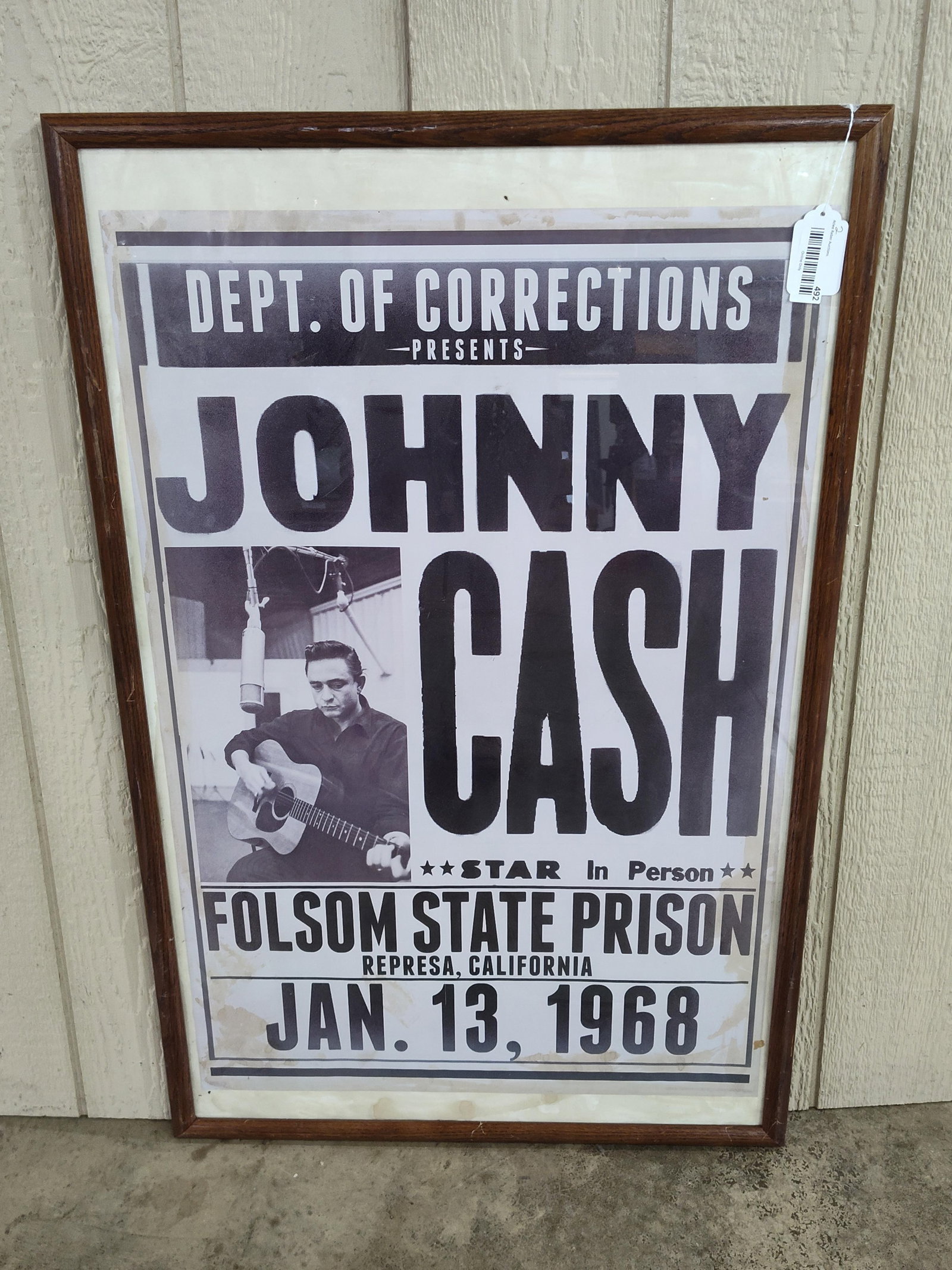 Framed Johnny Cash Folsom Prison Poster: A framed monochrome promotional poster commemorating Johnny Cash's historic 1968 performance at Folsom State Prison. The graphic features a central black-and-white photograph of the artist seated with