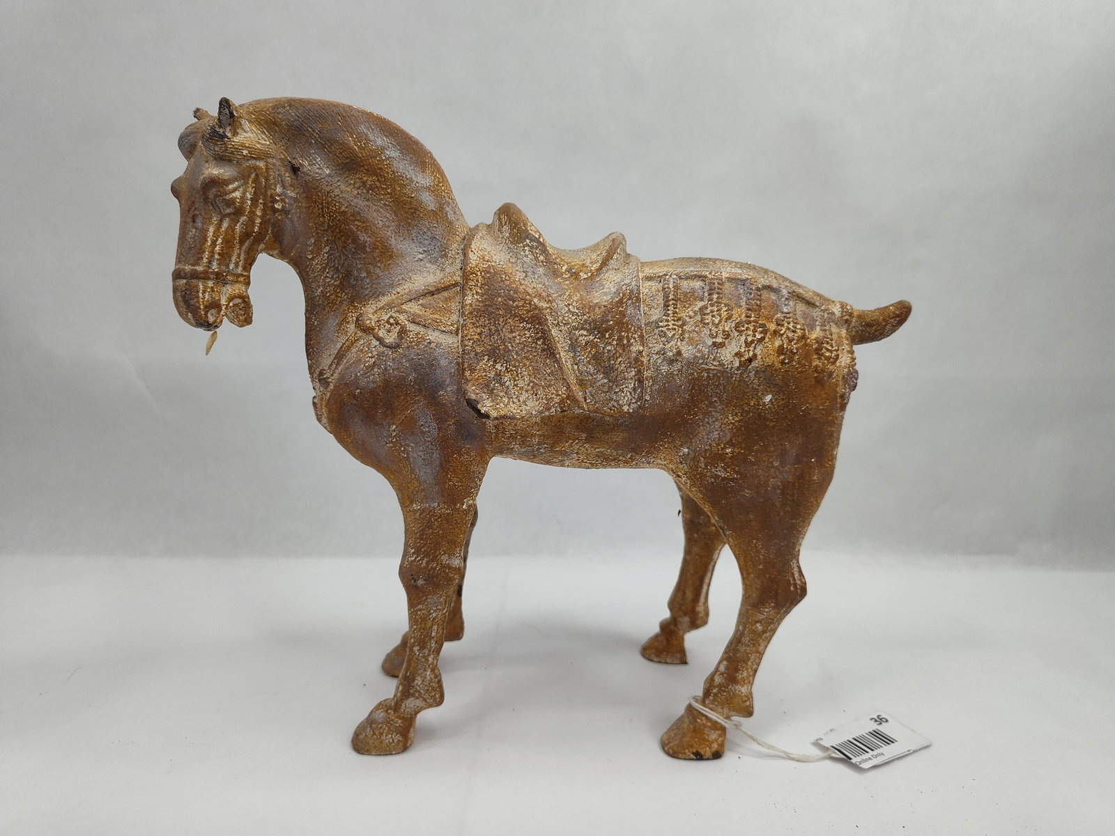 Cast Metal Tang Style Saddled Horse: A decorative cast metal figurine of a standing horse, modeled after the traditional aesthetic of Chinese Tang dynasty pottery. The figure is depicted in a static four-square pose with a docked tail.