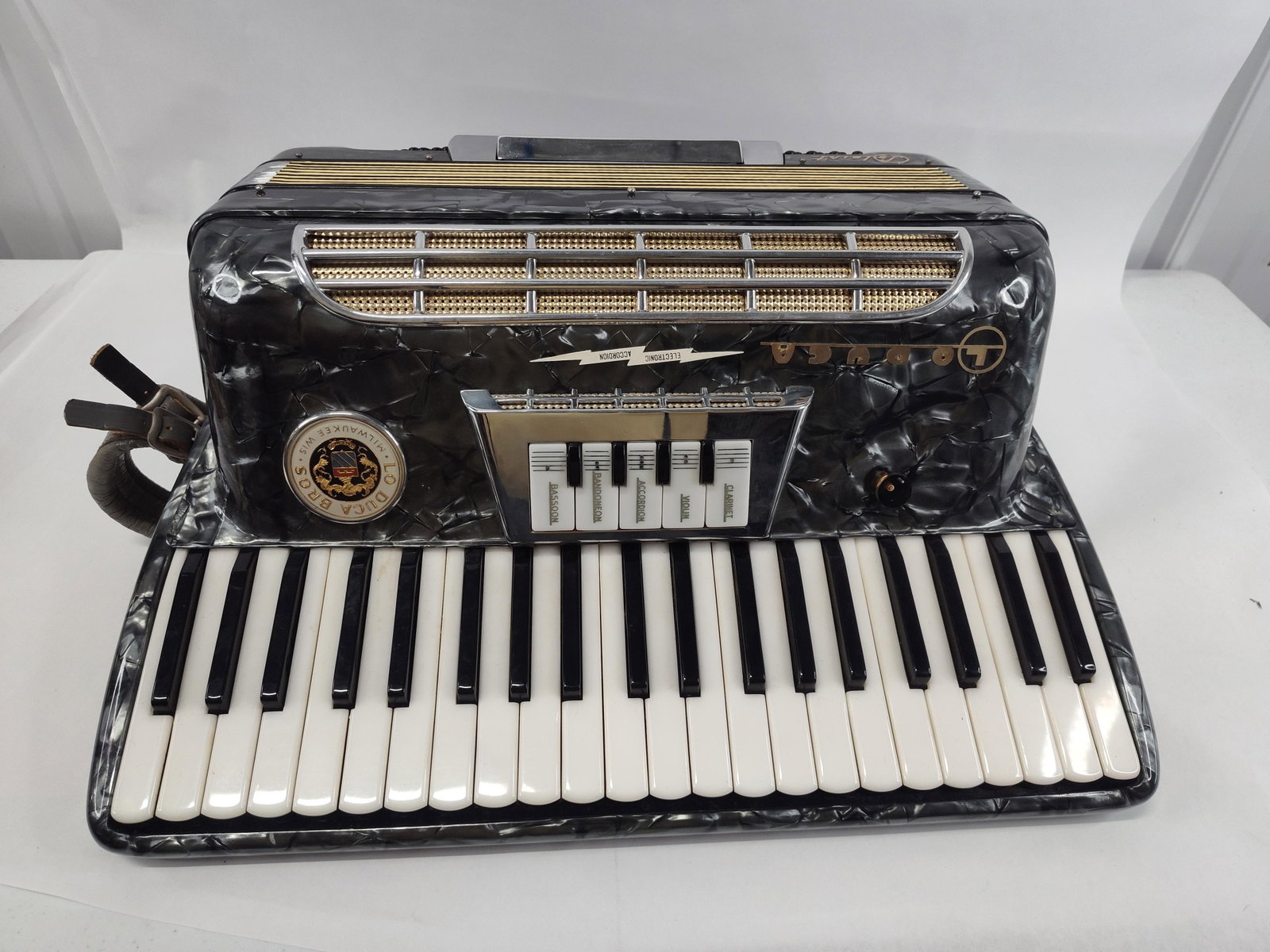 Lo Duca Bros. Italian Piano Accordion: This Italian piano accordion features a gray marbled pearloid celluloid body with chrome-plated and gold-tone metal grillwork. The treble section is equipped with 41 keys and a central register switch