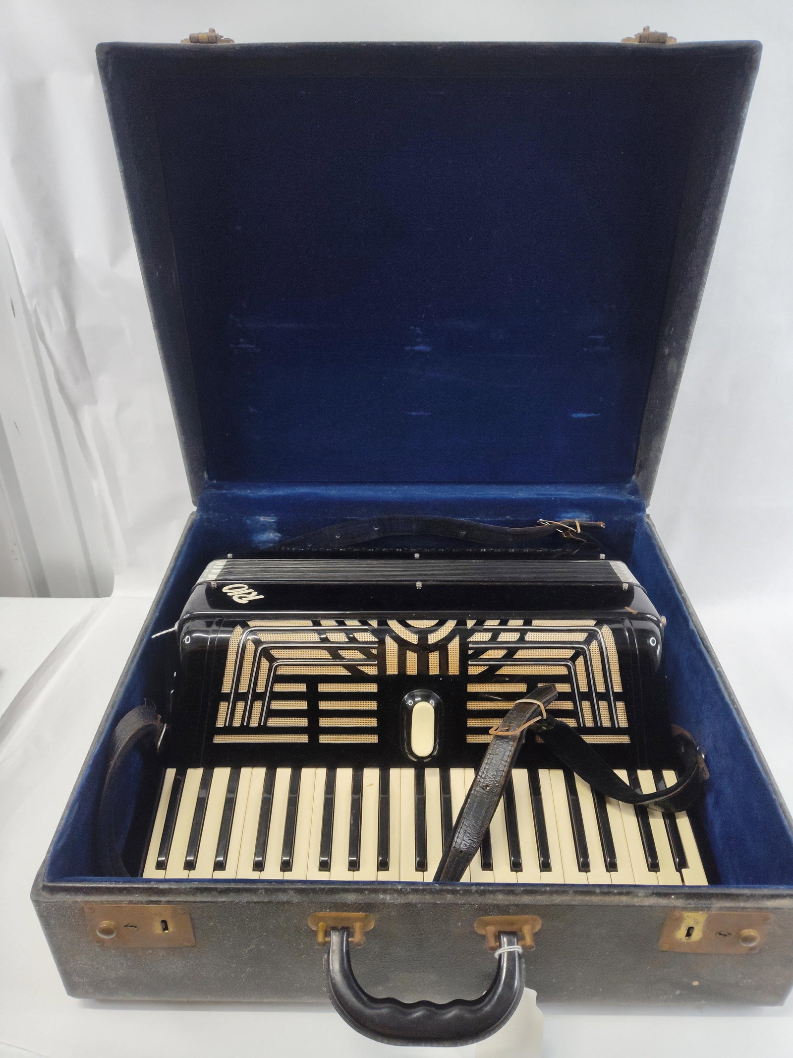 Rio 120-Bass Piano Accordion with Case: This piano accordion features a black celluloid body decorated with a geometric Art Deco-style grille in cream and silver tones. The instrument is configured with a 41-key piano keyboard and a