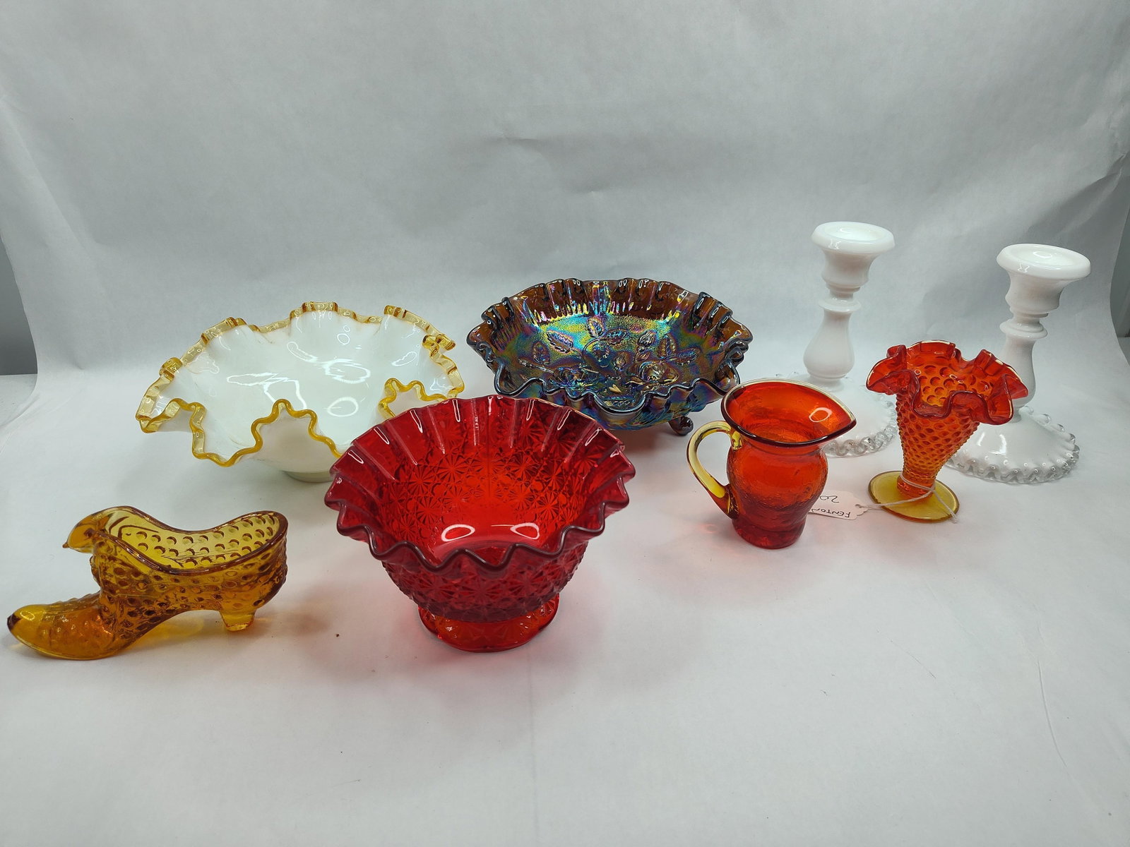 Fenton & Mid-C. Art Glass Group: This assortment of American art glass features several distinct styles and techniques. The collection includes a white milk glass bowl with a crimped amber-toned crest rim and a footed carnival glass 