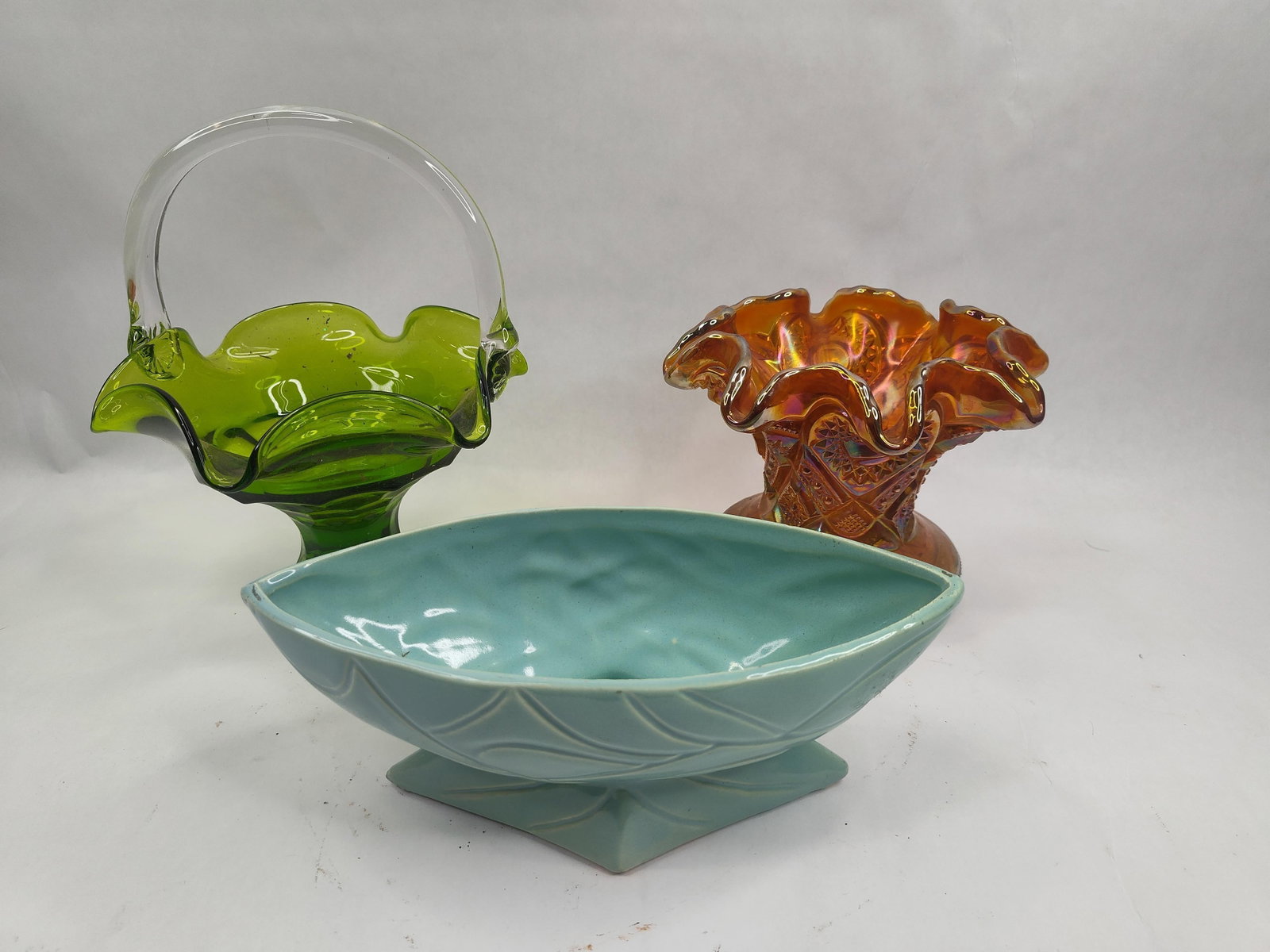 3 Robinson-Ransbottom Glass & Cer. Pots: This lot comprises three American decorative vessels. The first is a turquoise glazed ceramic planter of boat-shaped form with a pedestal base. The exterior is decorated with an embossed stylized