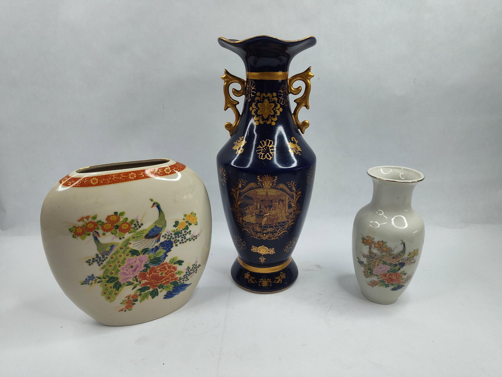 Set 3 Japanese Gilt Porc. Vases: A group of three Japanese ceramic vases of varying forms and decorative styles. The first is a Japanese-made porcelain vase of flattened ovoid form with a cream-colored crackle glaze. The front is