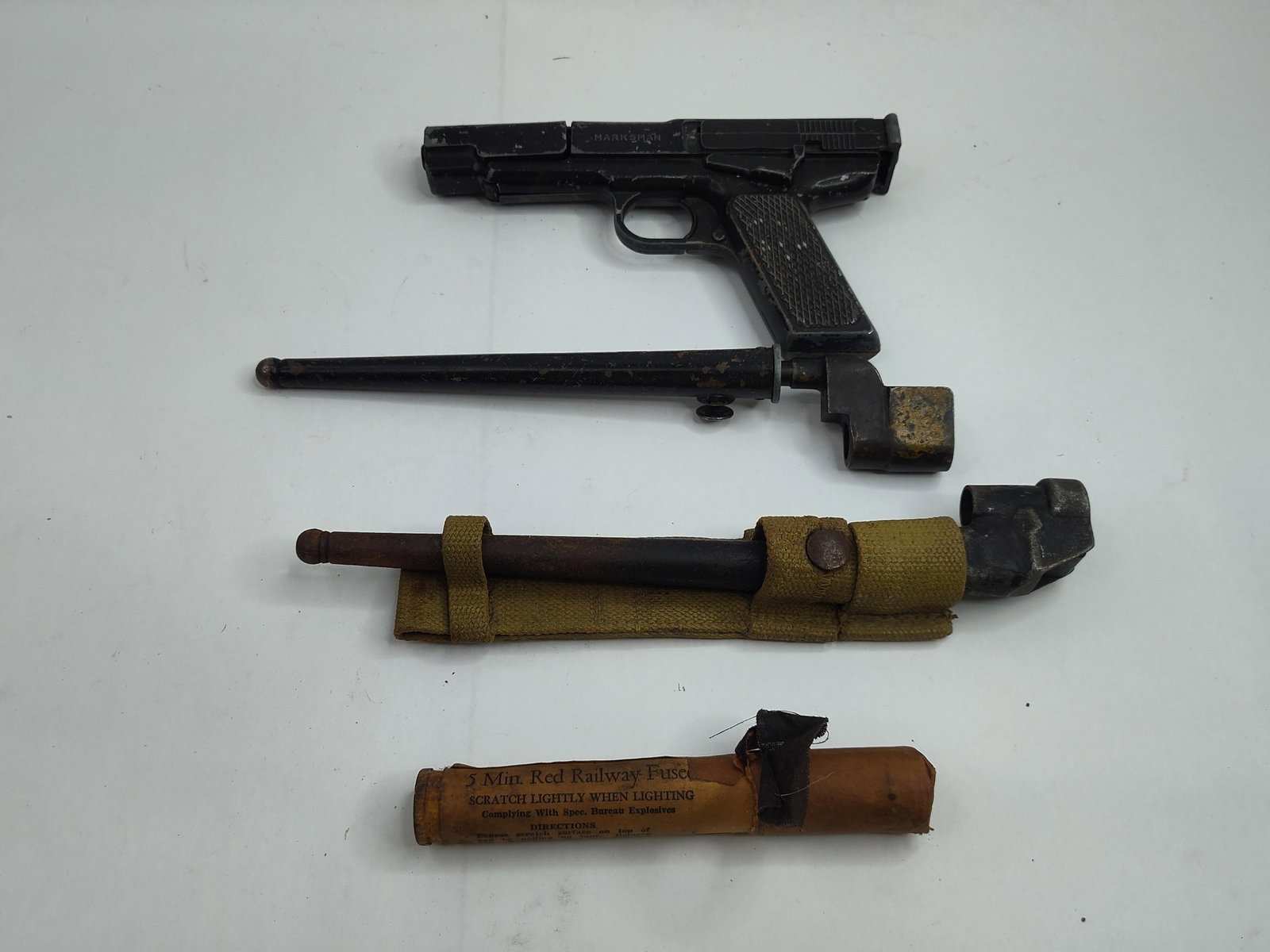 Military & Railroad Set w/ Air Pistol: A collection of militaria and railway equipment. The group features a spring-piston air pistol constructed with a black-finished die-cast metal frame and cross-checkered grips. The left side of the