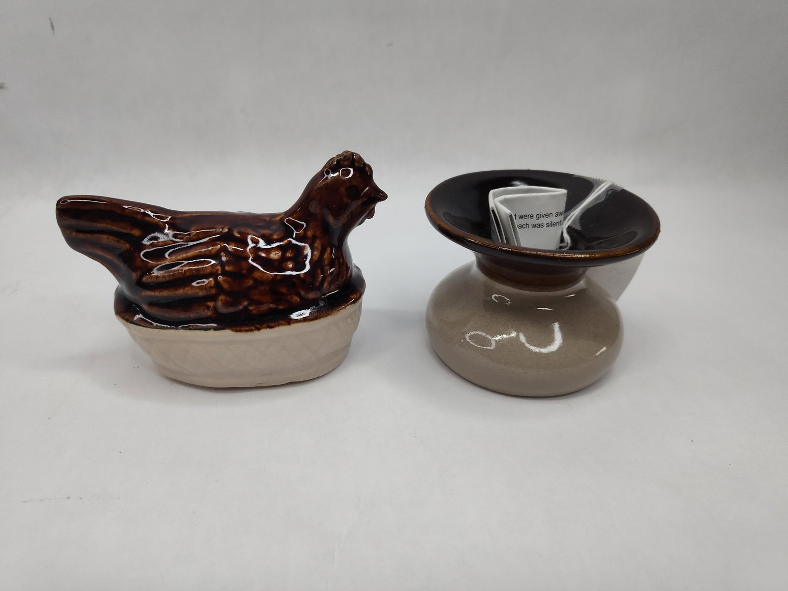 Pair Red Wing Stoneware Commemoratives: This lot comprises two commemorative stoneware pieces produced for the Red Wing Collectors Society. The first is a hen-on-nest covered baker featuring a dark brown drip glaze over a cream-colored base