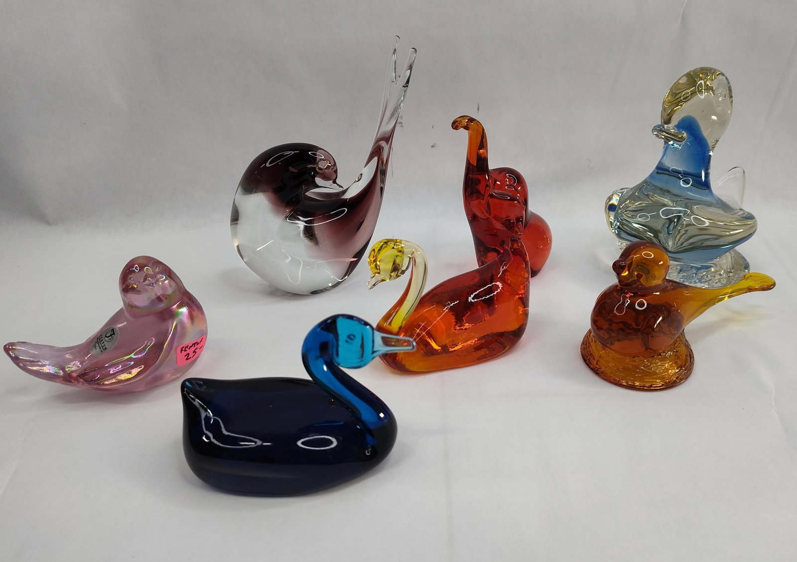 Set 7 Art Glass Animal Figures w/ Seal: A collection of seven art glass figurines in various animal forms, including several birds, an elephant, and a seal. The assortment features a variety of glassmaking techniques including sommerso