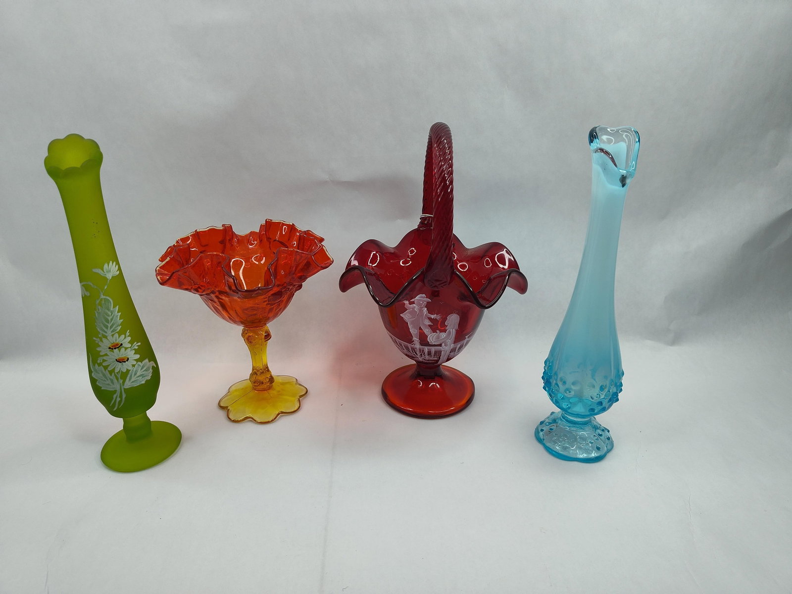 Fenton Glass Basket & Hobnail Vase lot: A collection of assorted North American art glass. The group features a tall, slender blue opalescent hobnail bud vase with a ruffled rim. The base of the blue vase has a molded mark within an oval re