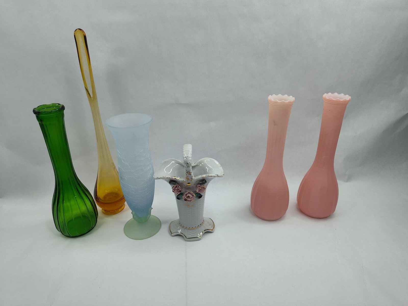 Set Glass & Ceramic Vases: A group of assorted decorative vessels comprising glass and ceramic examples in various styles. The collection includes a tall swung glass vase in amber with an elongated neck and a weighted bulbous b