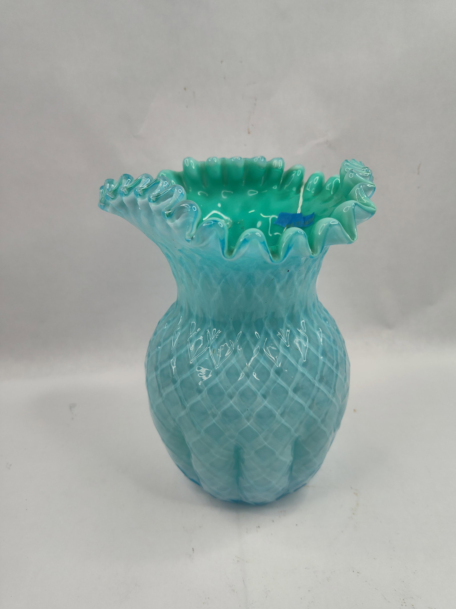 Blue & Green Glass Ruffled Rim Vase: A cased art glass vase featuring a bulbous body and a wide, ruffled rim. The vessel is constructed with a solid light green interior and a light blue exterior. The exterior surface is decorated with