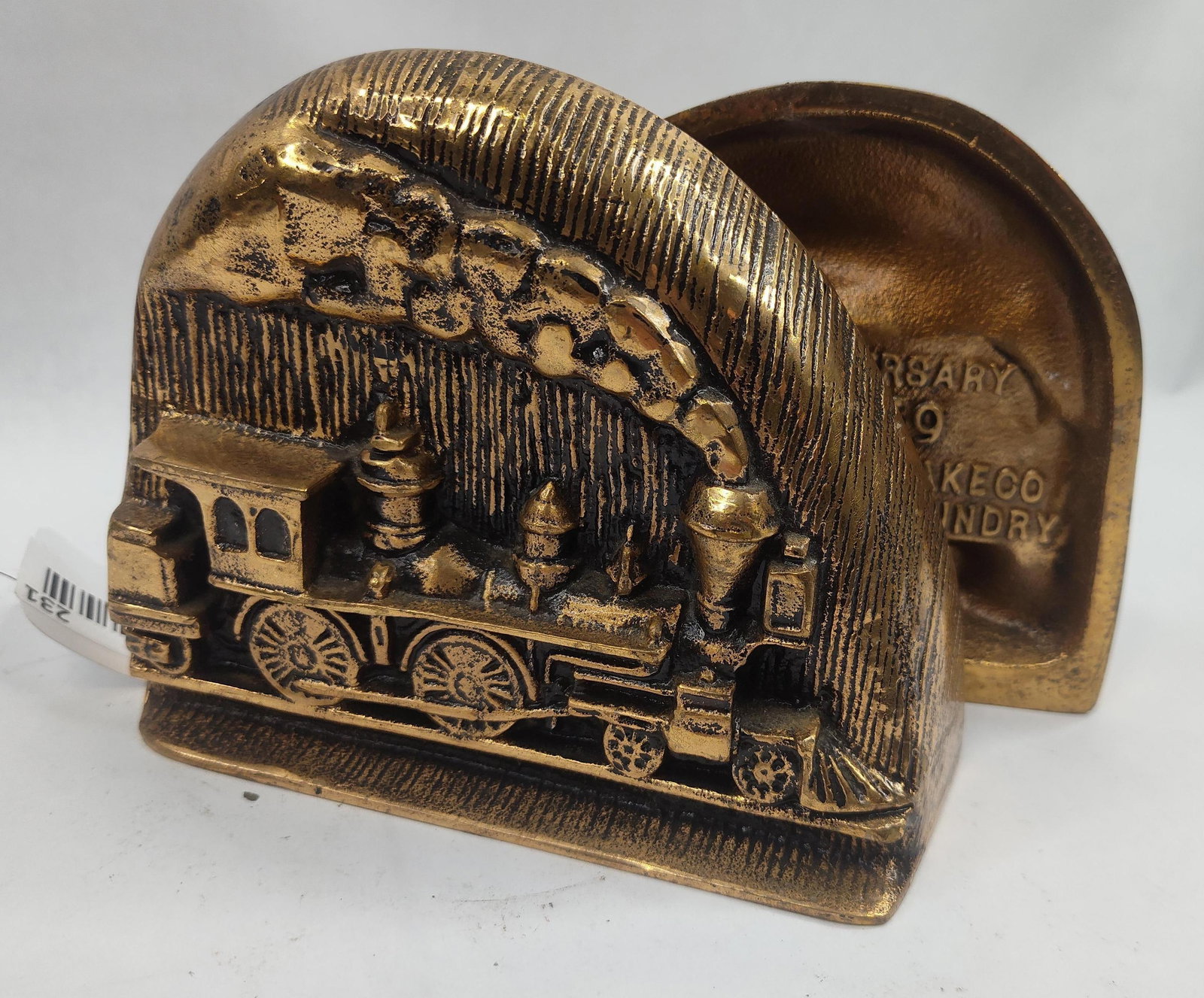Pair Westinghouse Train Bookends, Metal: A pair of cast metal bookends with a brass-toned finish, produced to commemorate the centennial of the Westinghouse Air Brake Co. Each bookend features a high-relief depiction of a 19th-century steam