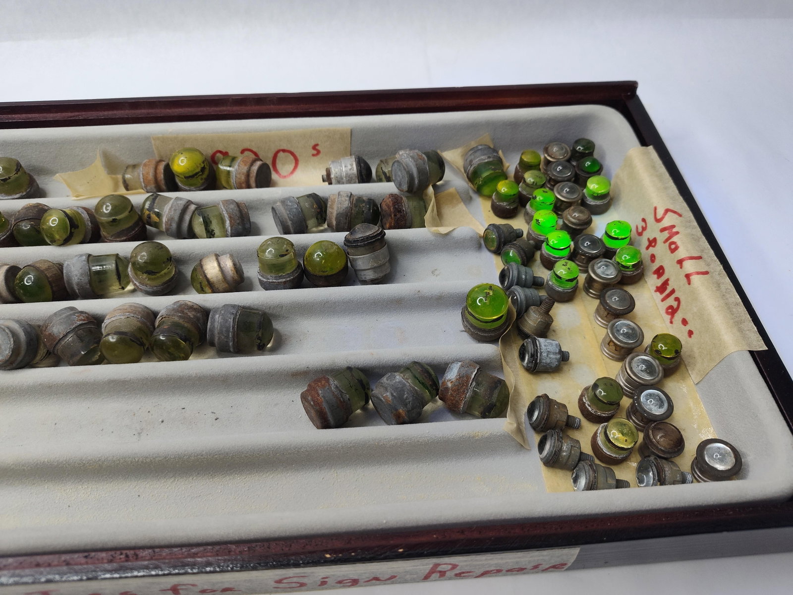 Set Uranium Glass Catseye Refl: An assortment of glass reflectors designed for sign and road marker repair, housed in a partitioned wooden display tray with a gray flocked interior. The collection features a variety of