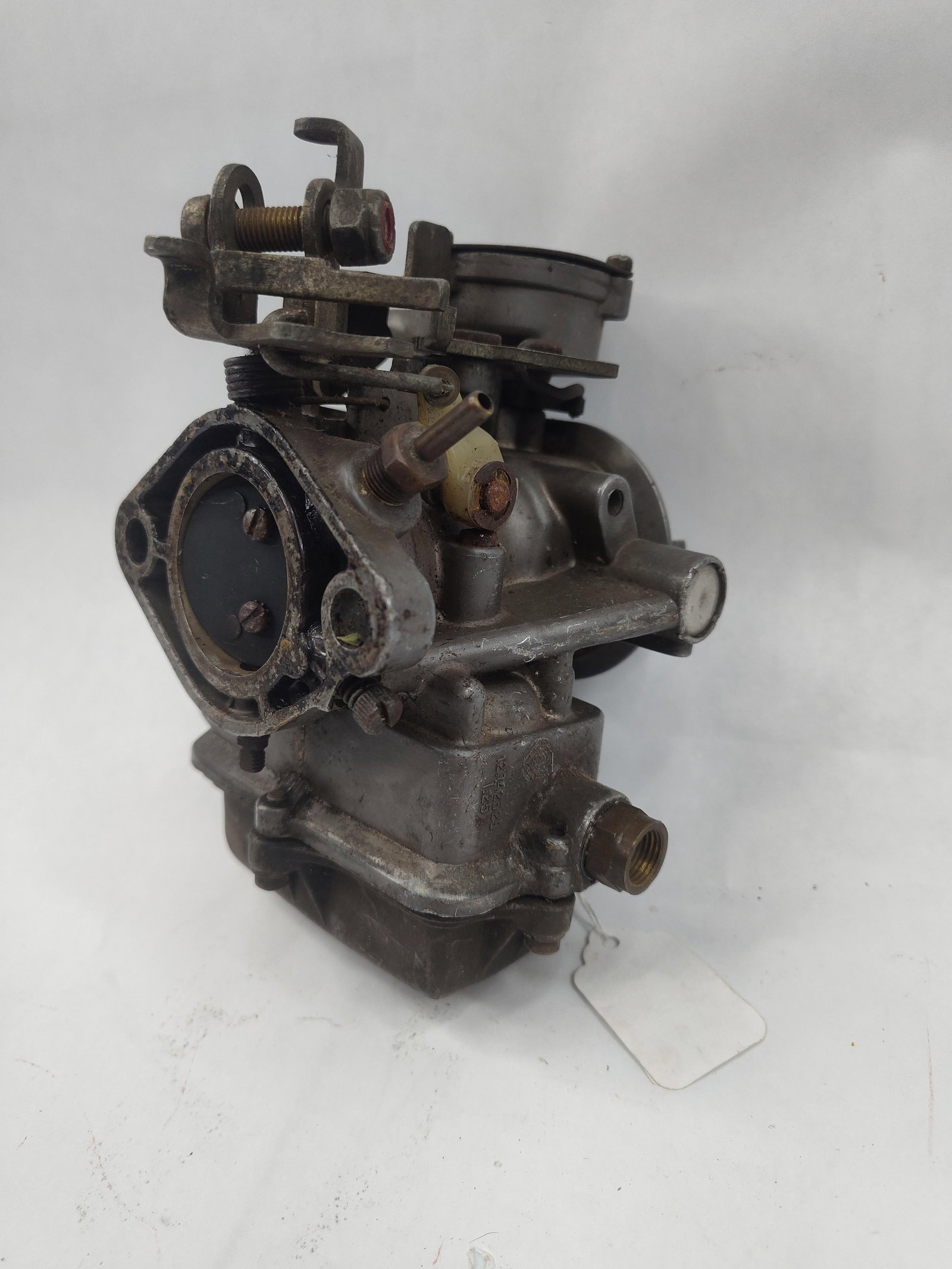 Holley Model 1920 Carburetor: A American-made single-barrel carburetor constructed of cast metal with steel and brass components. The unit features a throttle and choke linkage assembly, a fuel inlet port with brass threading,